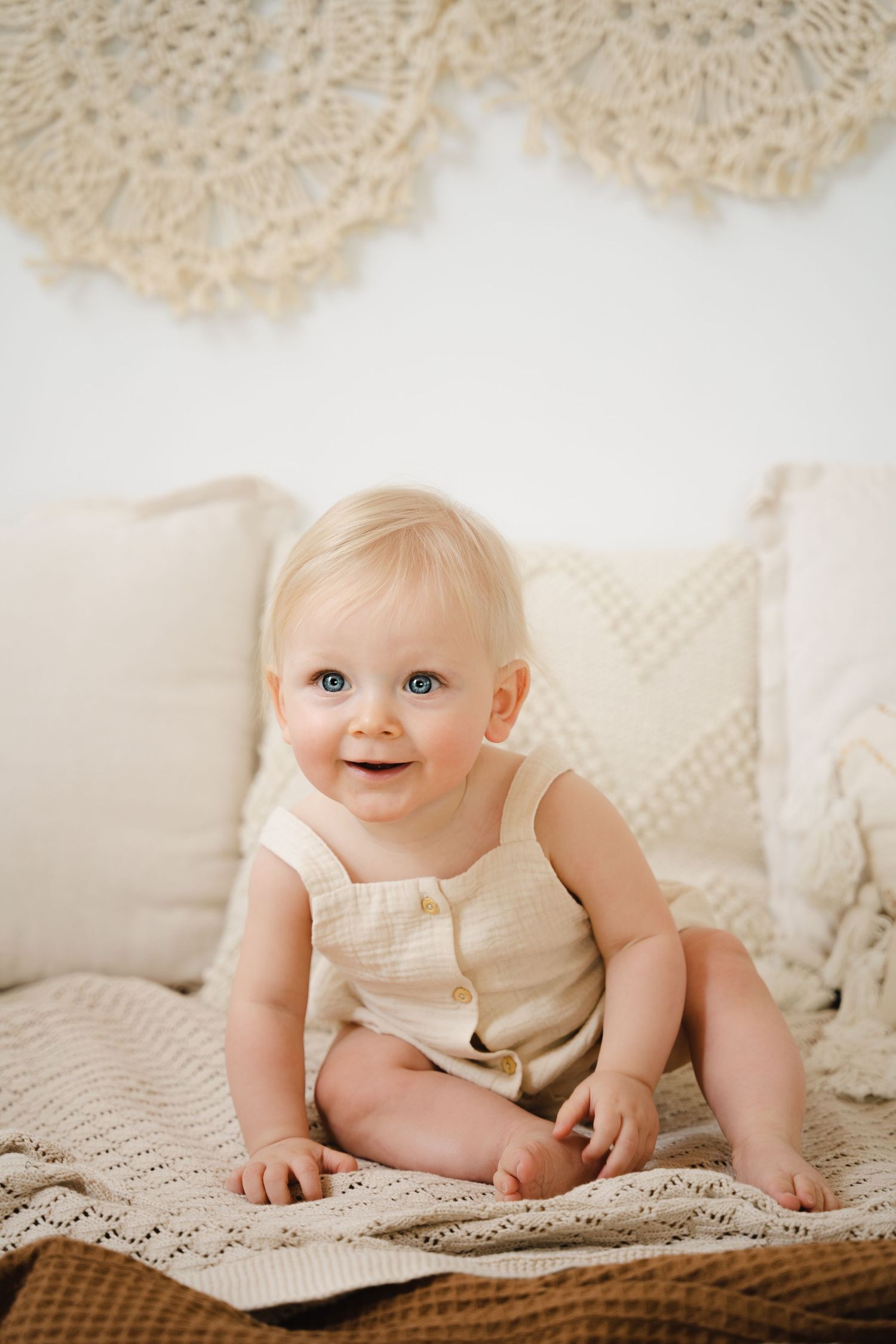foto van vrolijke baby die net kan zitten tijdens baby photoshoot in fotostudio in zandhoven