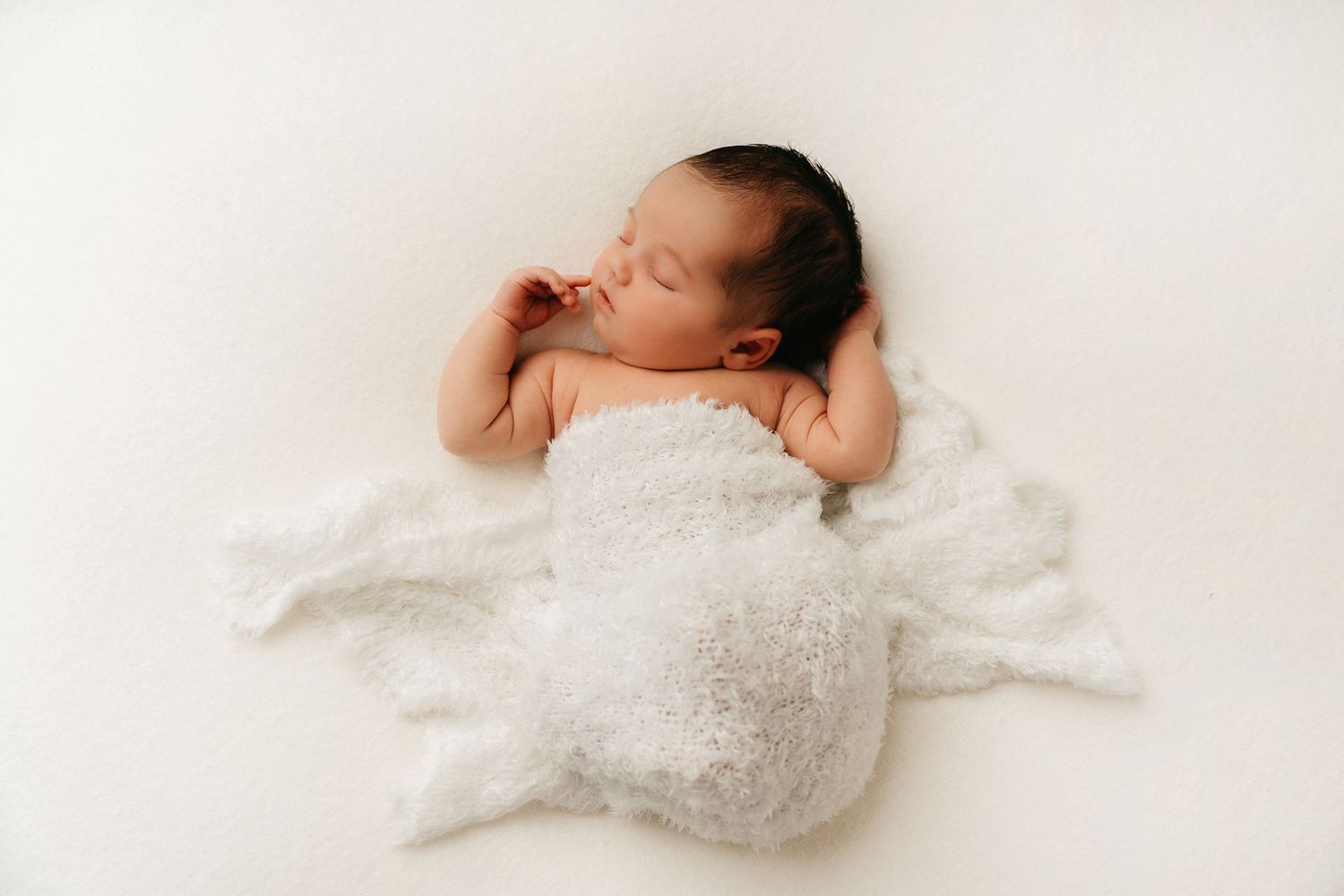 een foto van een slapende baby in een tijdloze setting tijdens een newborn reportage in studio in zandhoven