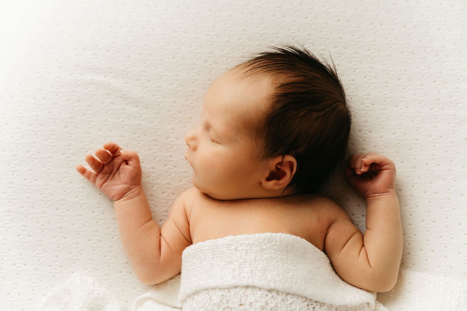 een foto van een slapende baby in een tijdloze setting tijdens een newborn reportage in studio in zandhoven