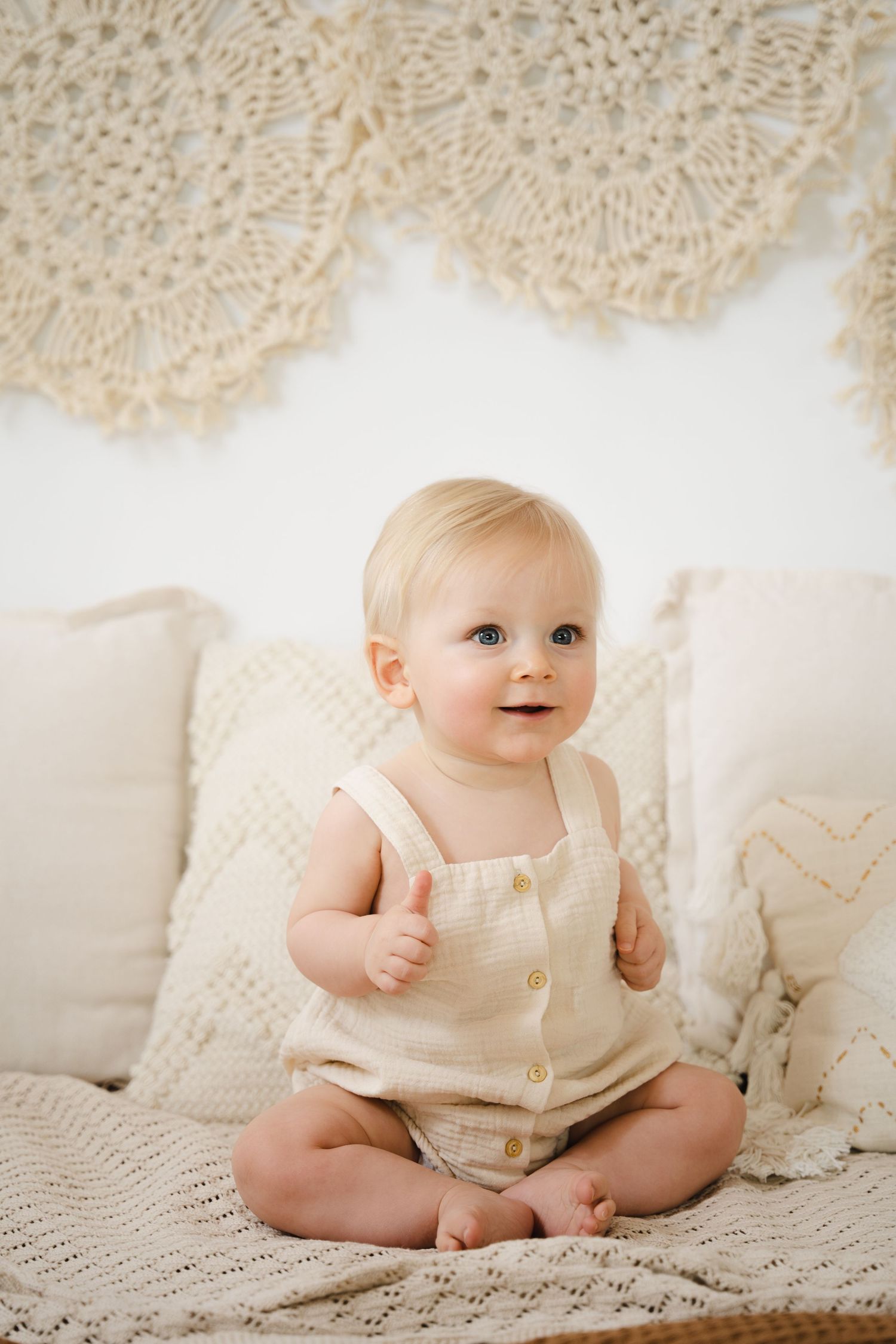 foto van vrolijke baby die net kan zitten tijdens baby photoshoot in fotostudio in zandhoven