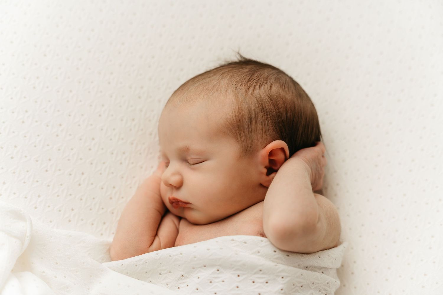 een foto van een slapende baby in een tijdloze setting tijdens een newborn reportage in studio in zandhoven