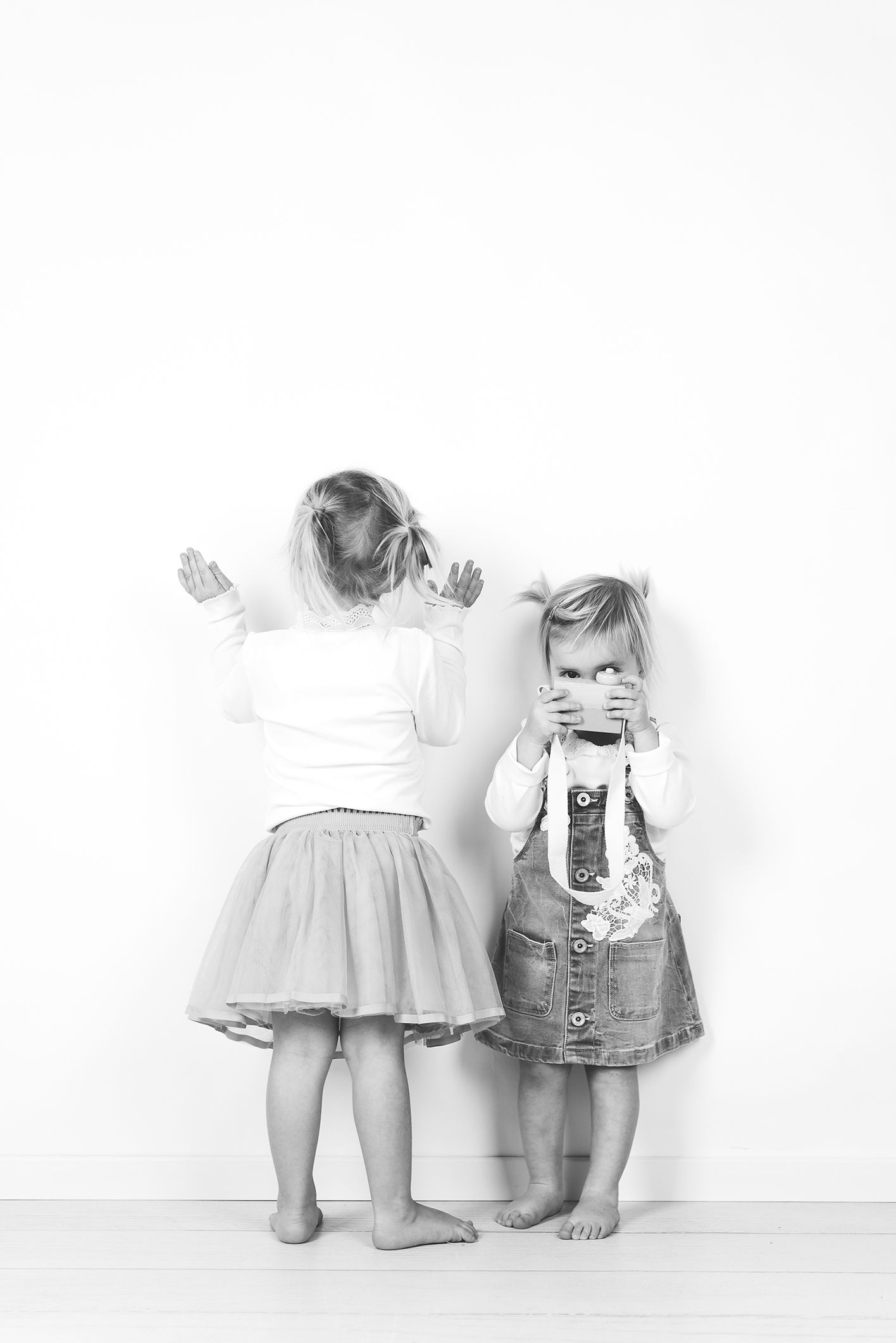 foto van kinderen die spelen tijdens een fotosessie in een wit decor in een fotostudio in zandhoven