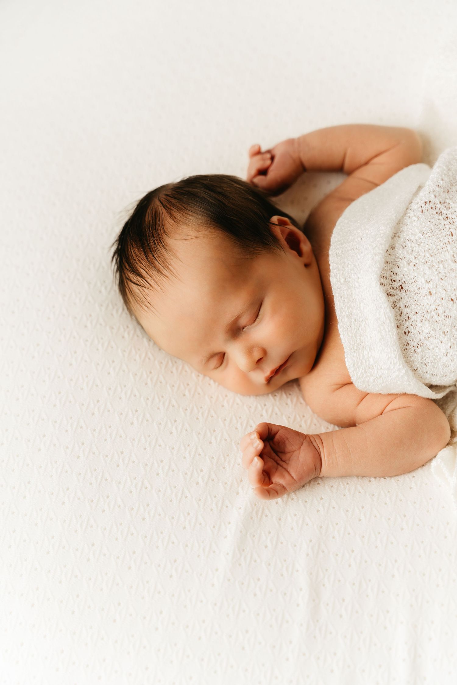 een foto van een slapende baby in een tijdloze setting tijdens een newborn reportage in studio in zandhoven