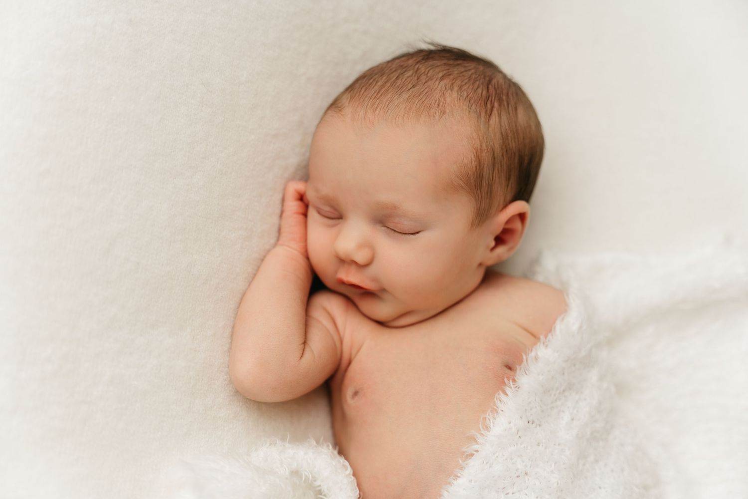 een foto van een slapende baby in een tijdloze setting tijdens een newborn reportage in studio in zandhoven