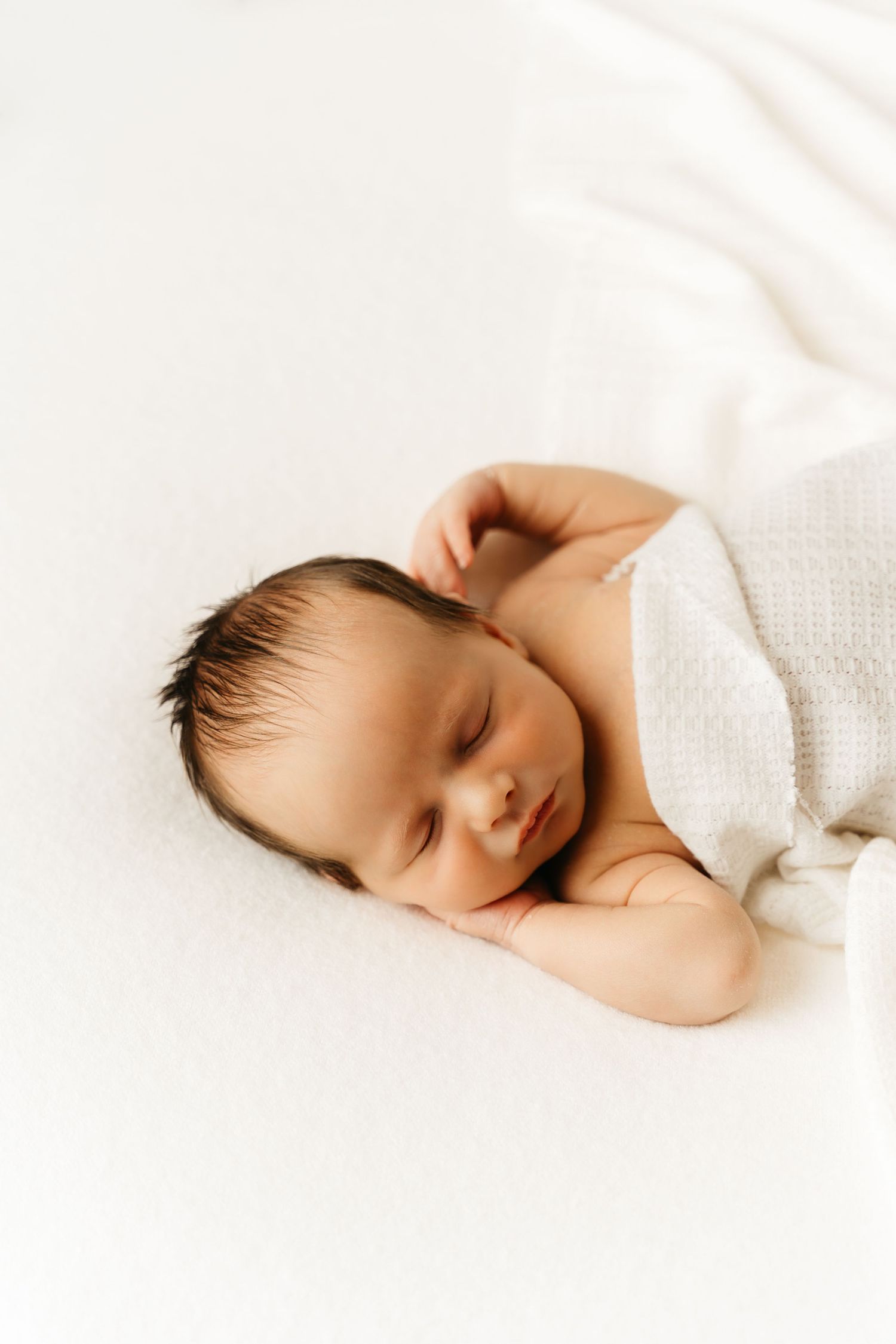 een foto van een slapende baby in een tijdloze setting tijdens een newborn reportage in studio in zandhoven