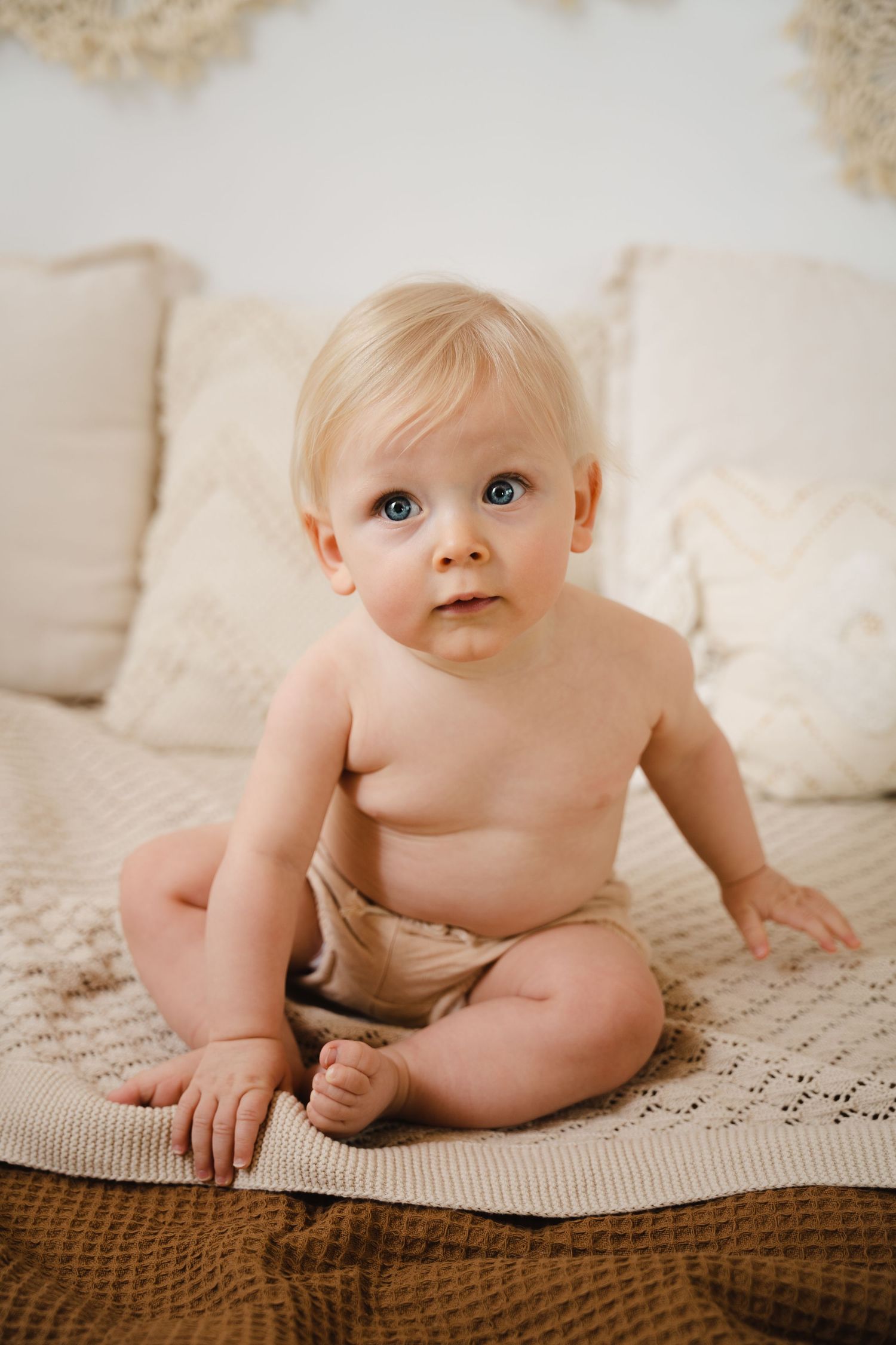 foto van vrolijke baby die net kan zitten tijdens fotoshoot in fotostudio in zandhoven