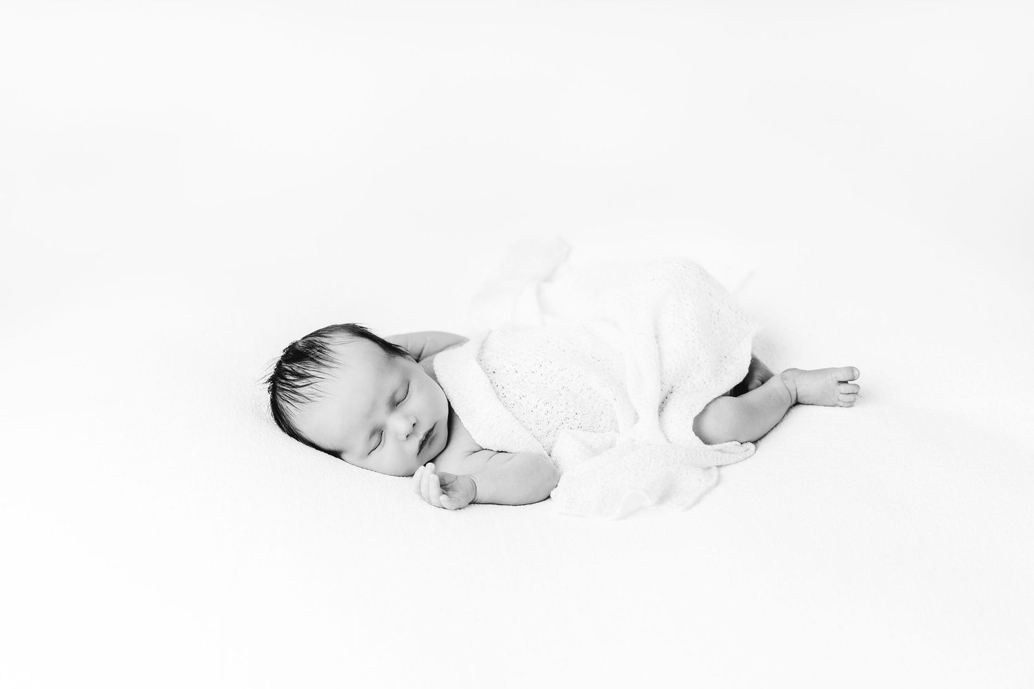 een foto van een slapende baby in een tijdloze setting tijdens een newborn reportage in studio in zandhoven