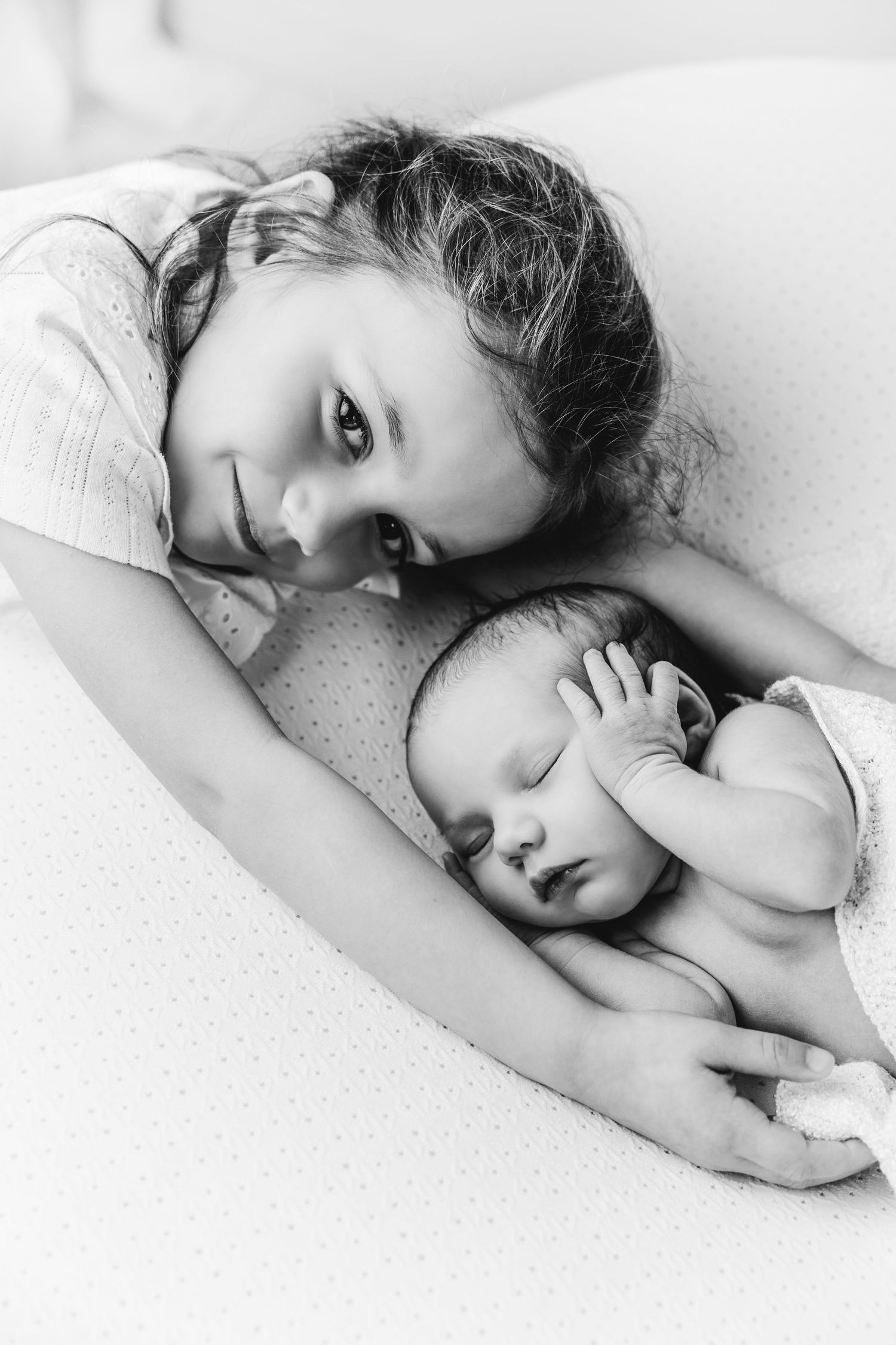 foto van newborn baby samen met zusjes tijdens een newborn photoshoot in Antwerpen