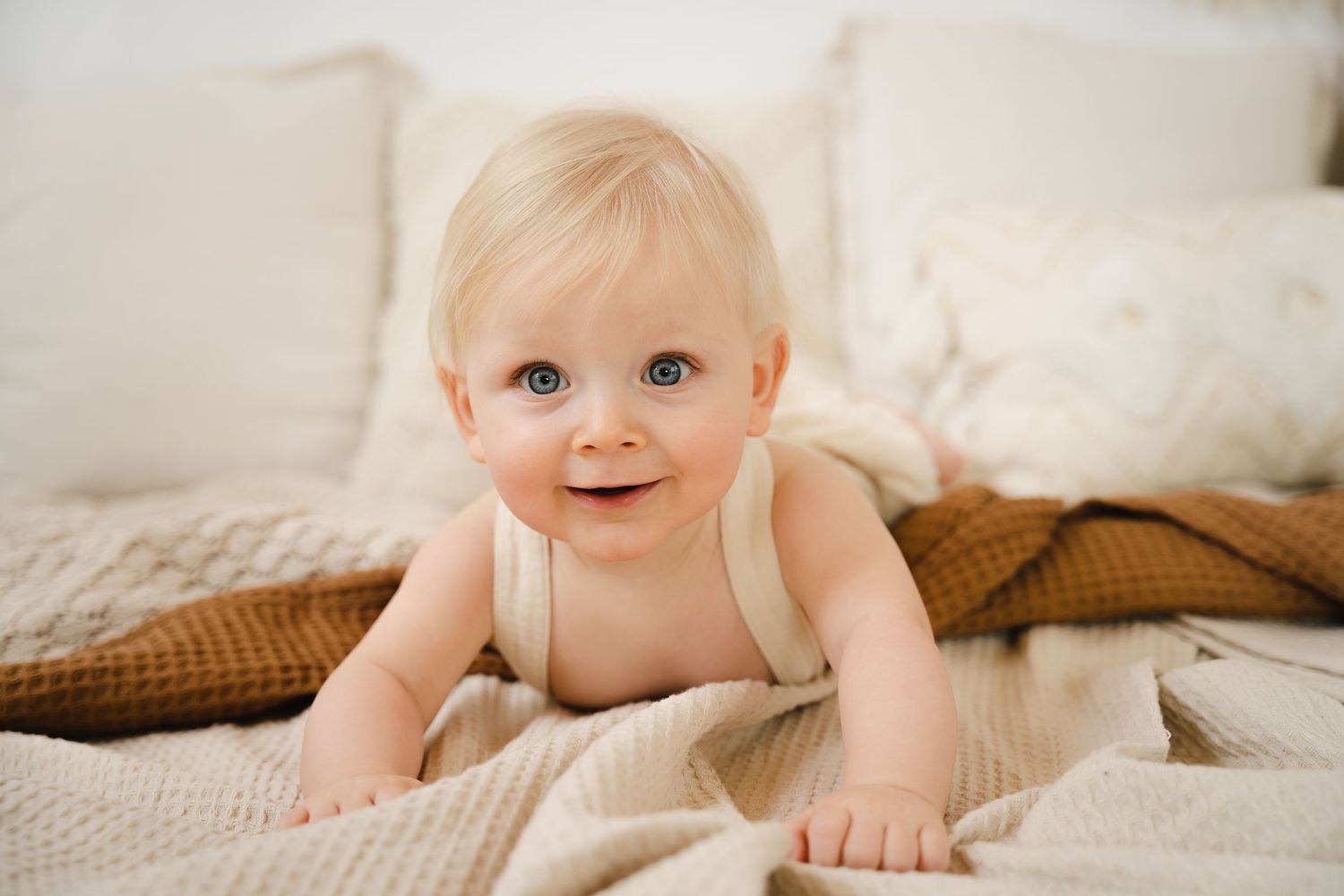 foto van vrolijke baby die net kan zitten tijdens sittersessie in fotostudio in zandhoven