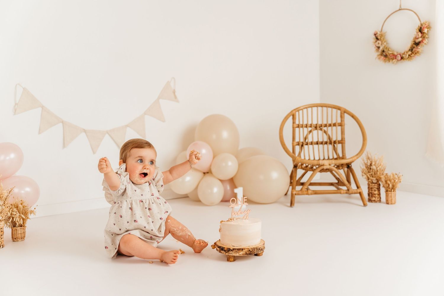 meisje van 1 jaar tijdens cakesmashreportage in feestelijk beige decor in Zandhoven