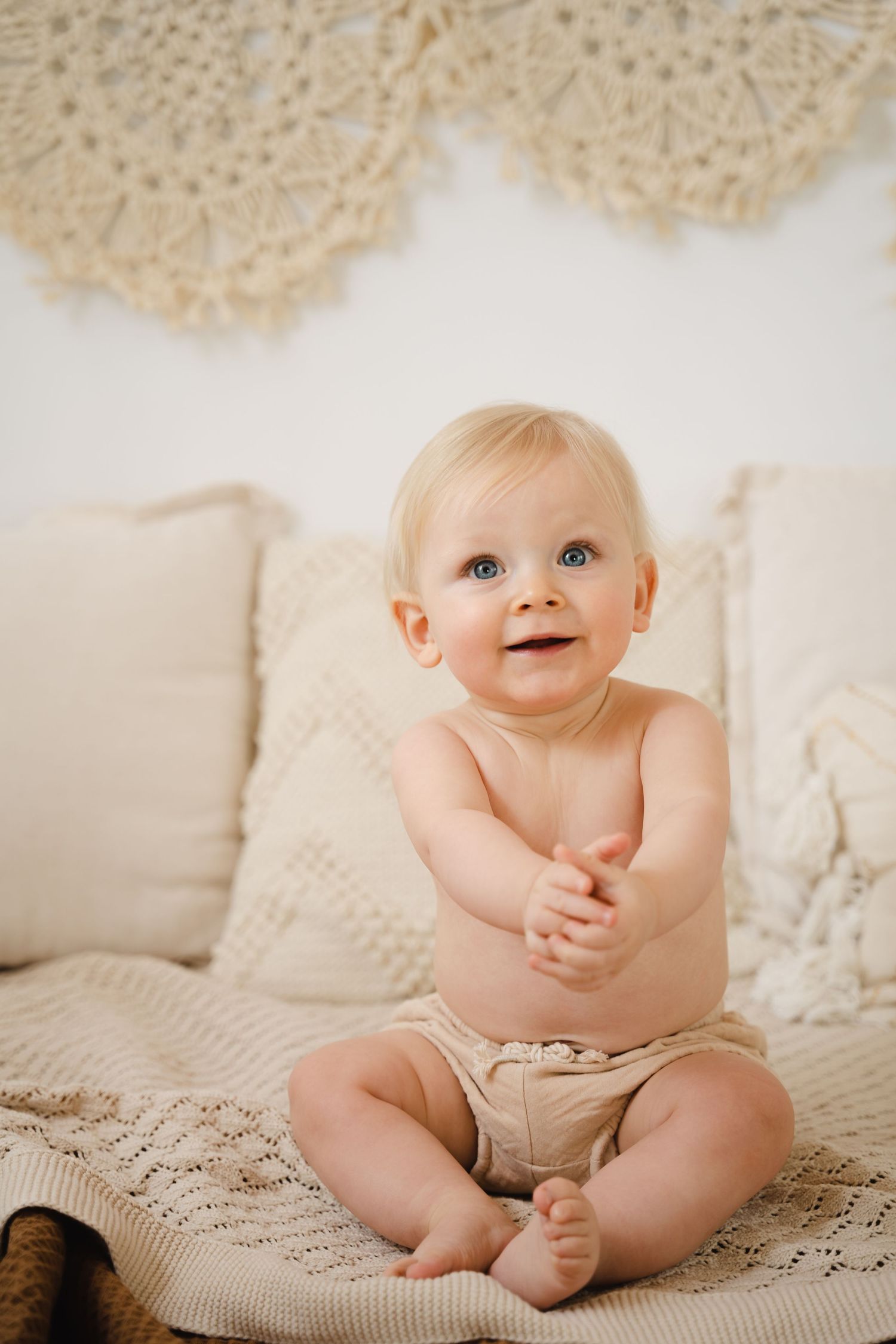foto van vrolijke baby die net kan zitten tijdens fotoshoot in fotostudio in foto van vrolijke baby die net kan zitten tijdens sittersessie