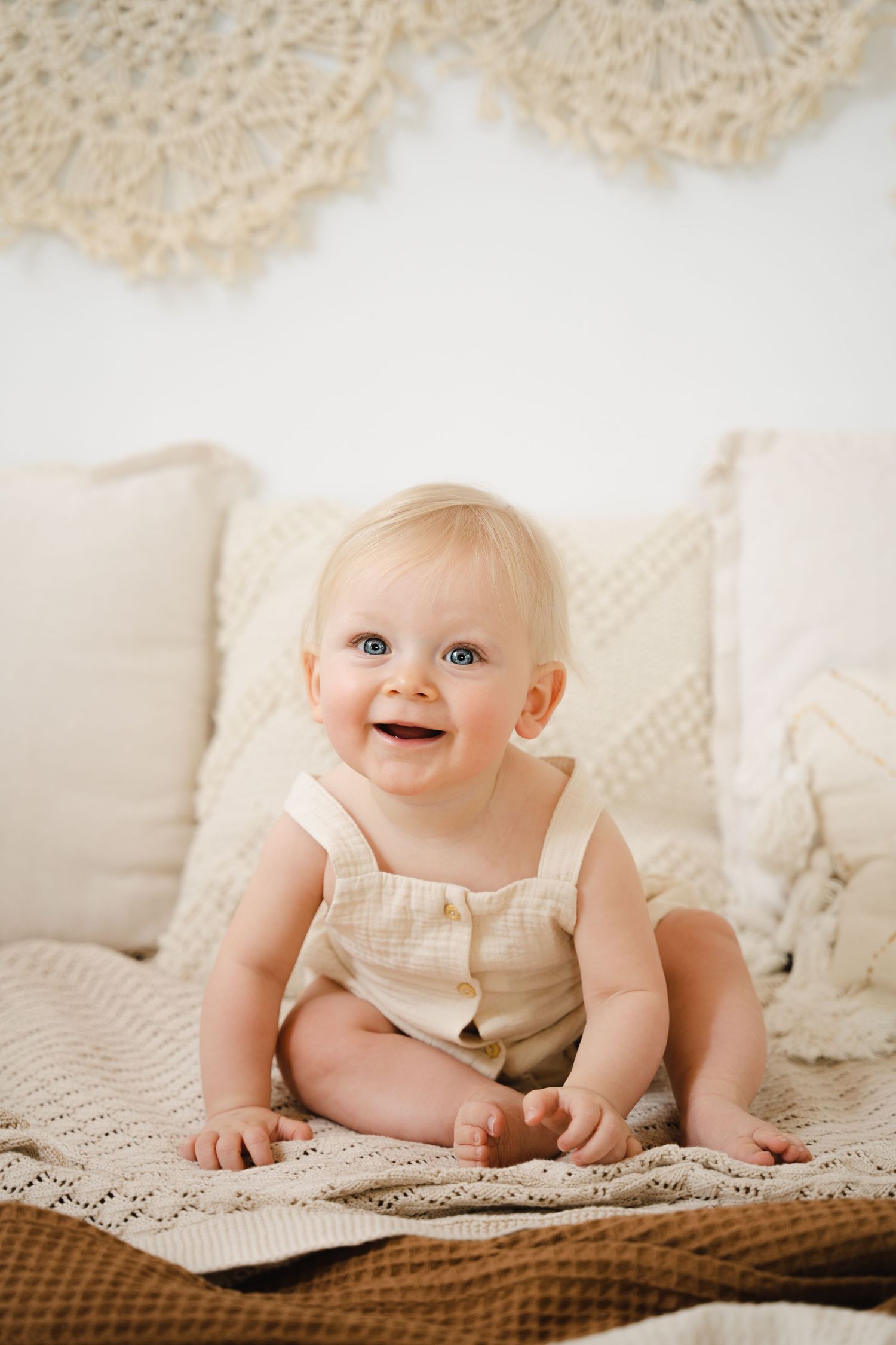 foto van vrolijke baby die net kan zitten tijdens baby photoshoot in fotostudio in zandhoven