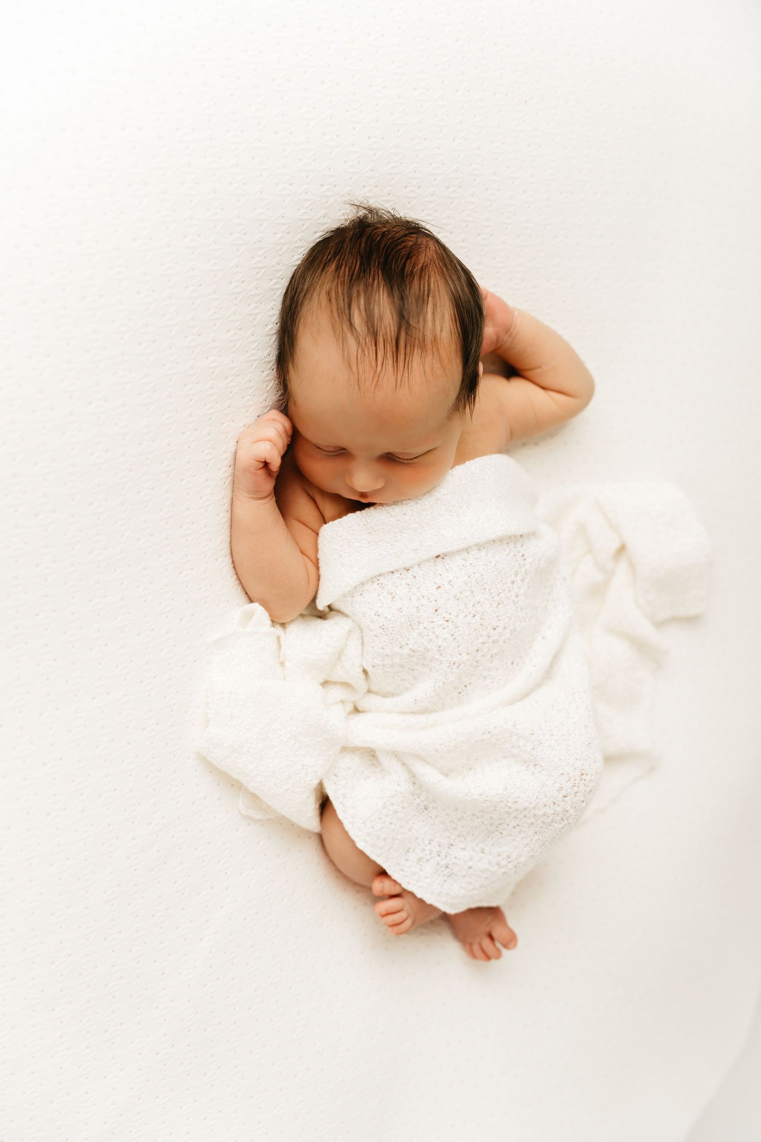 een foto van een slapende baby in een tijdloze setting tijdens een newborn reportage in studio in zandhoven