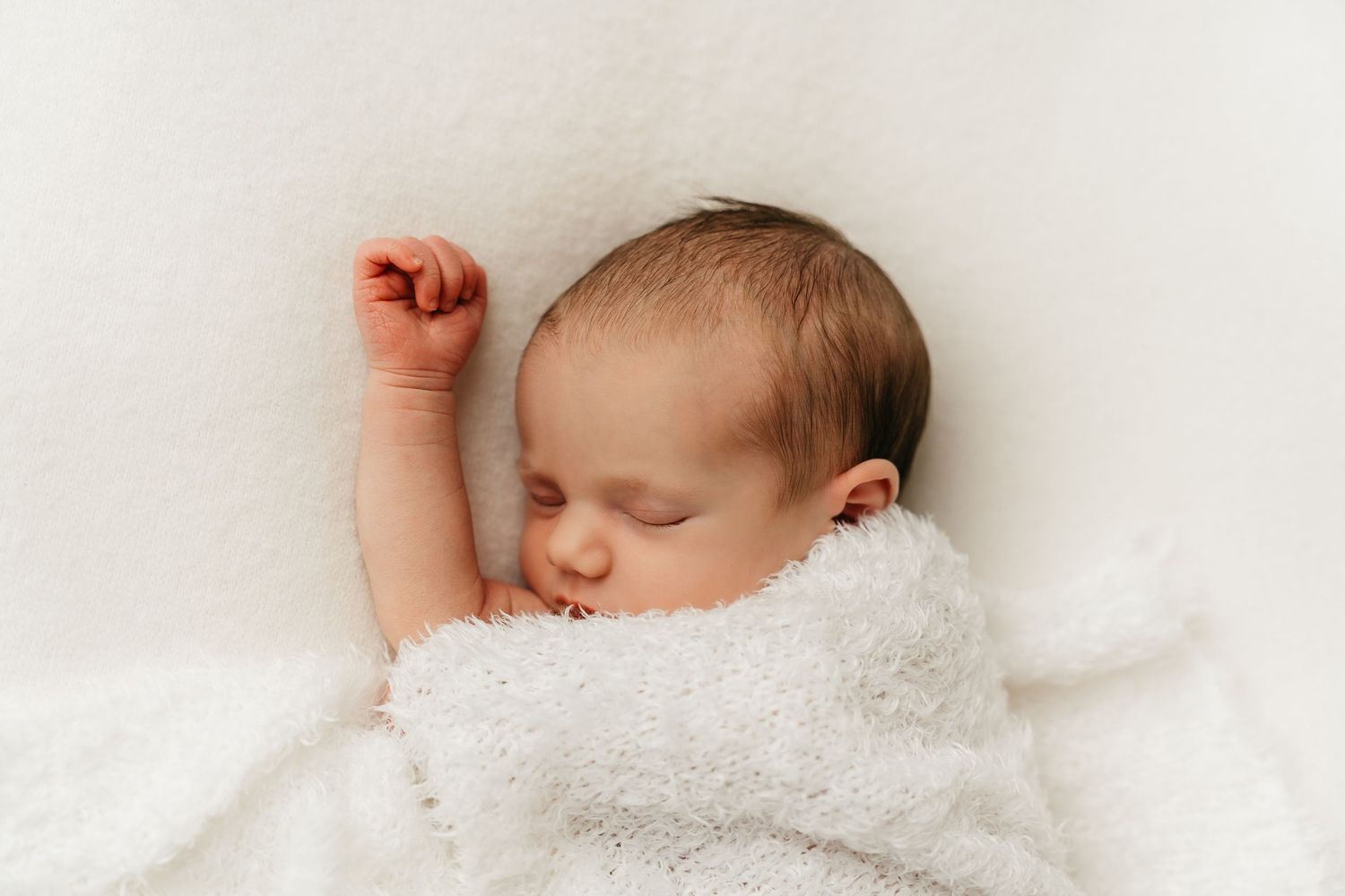 een foto van een slapende baby in een tijdloze setting tijdens een newborn reportage in studio in zandhoven