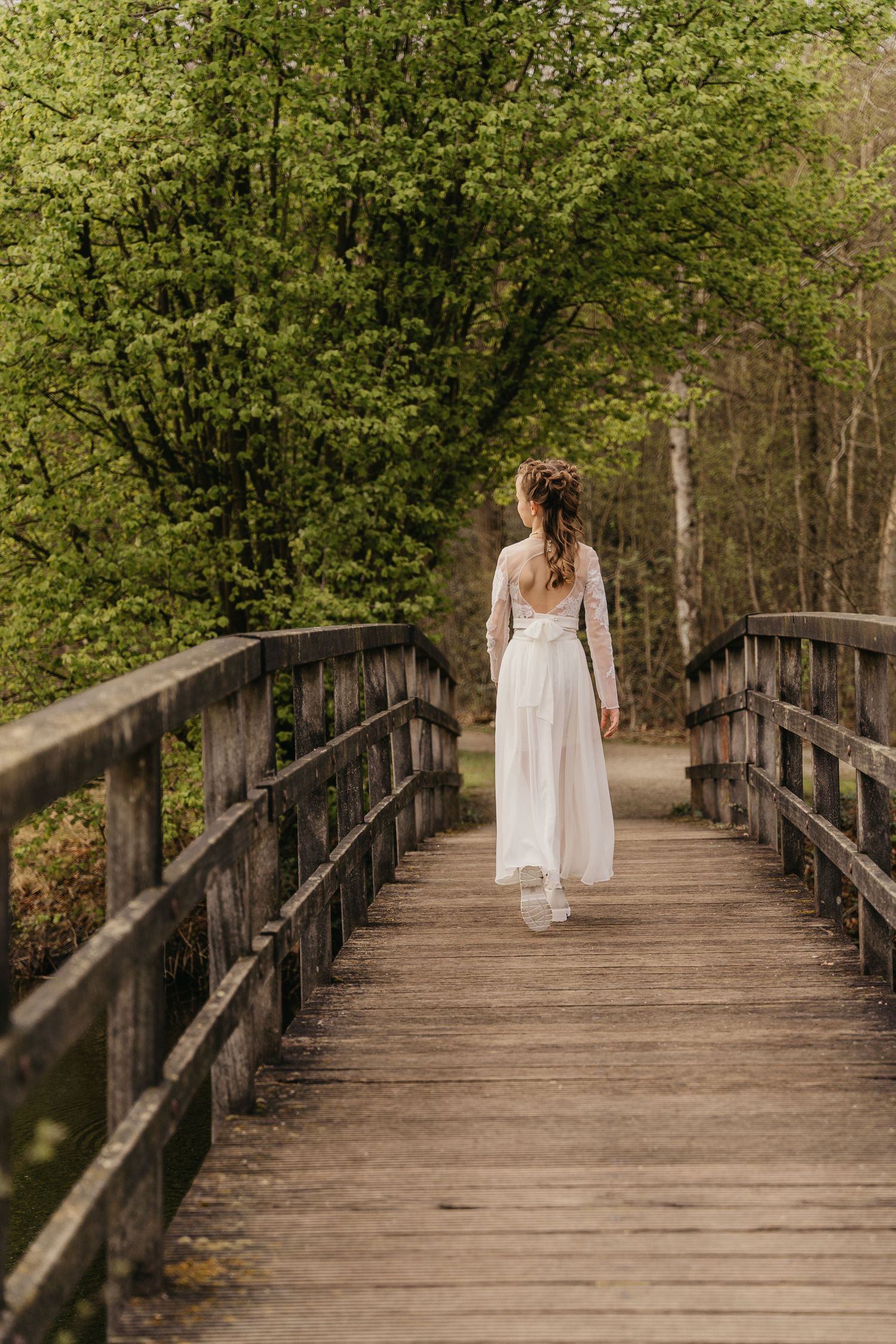 meisje in witte communiekleding tijdens communiereportage in natuur in Oelegem