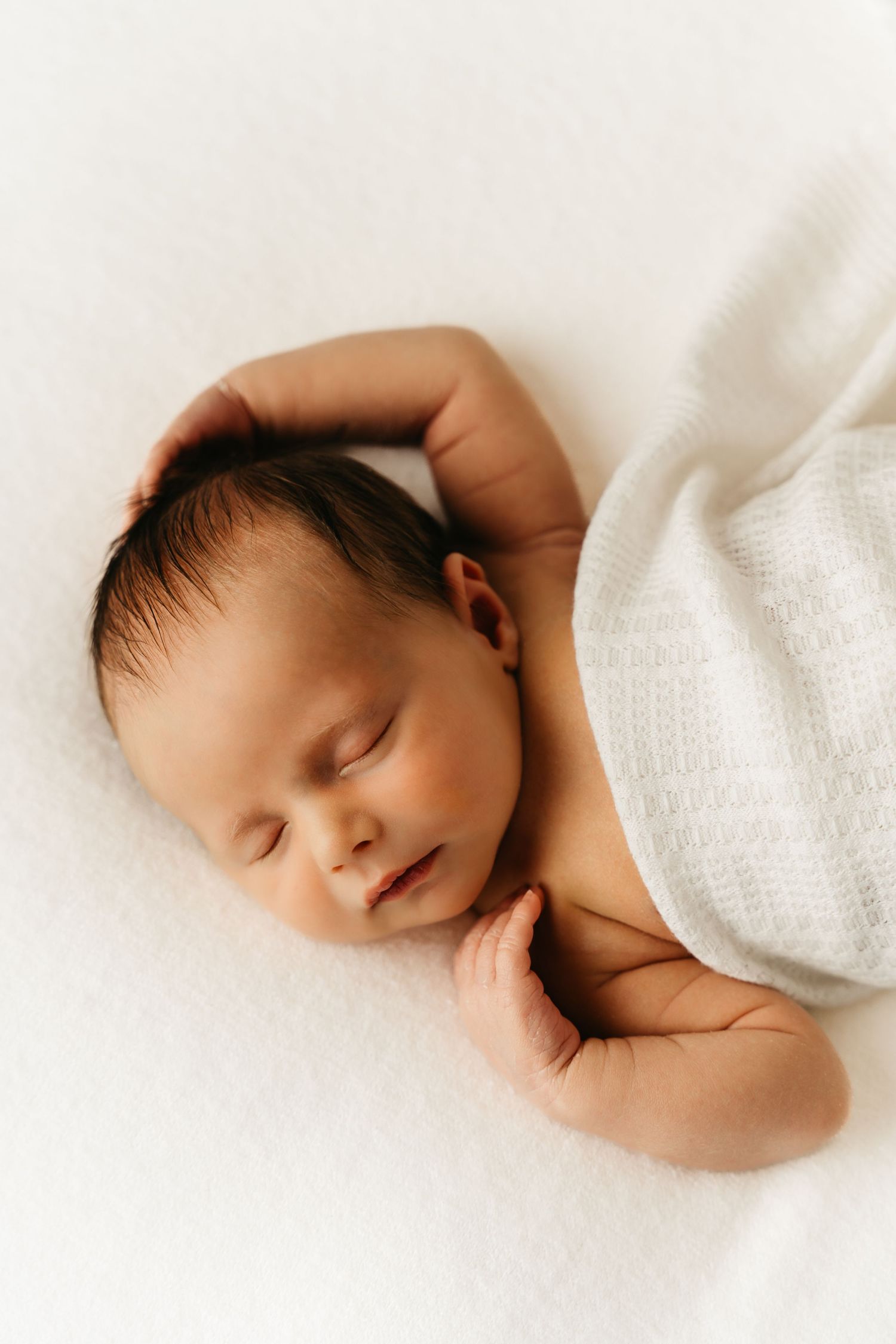 een foto van een slapende baby in een tijdloze setting tijdens een newborn reportage in studio in zandhoven