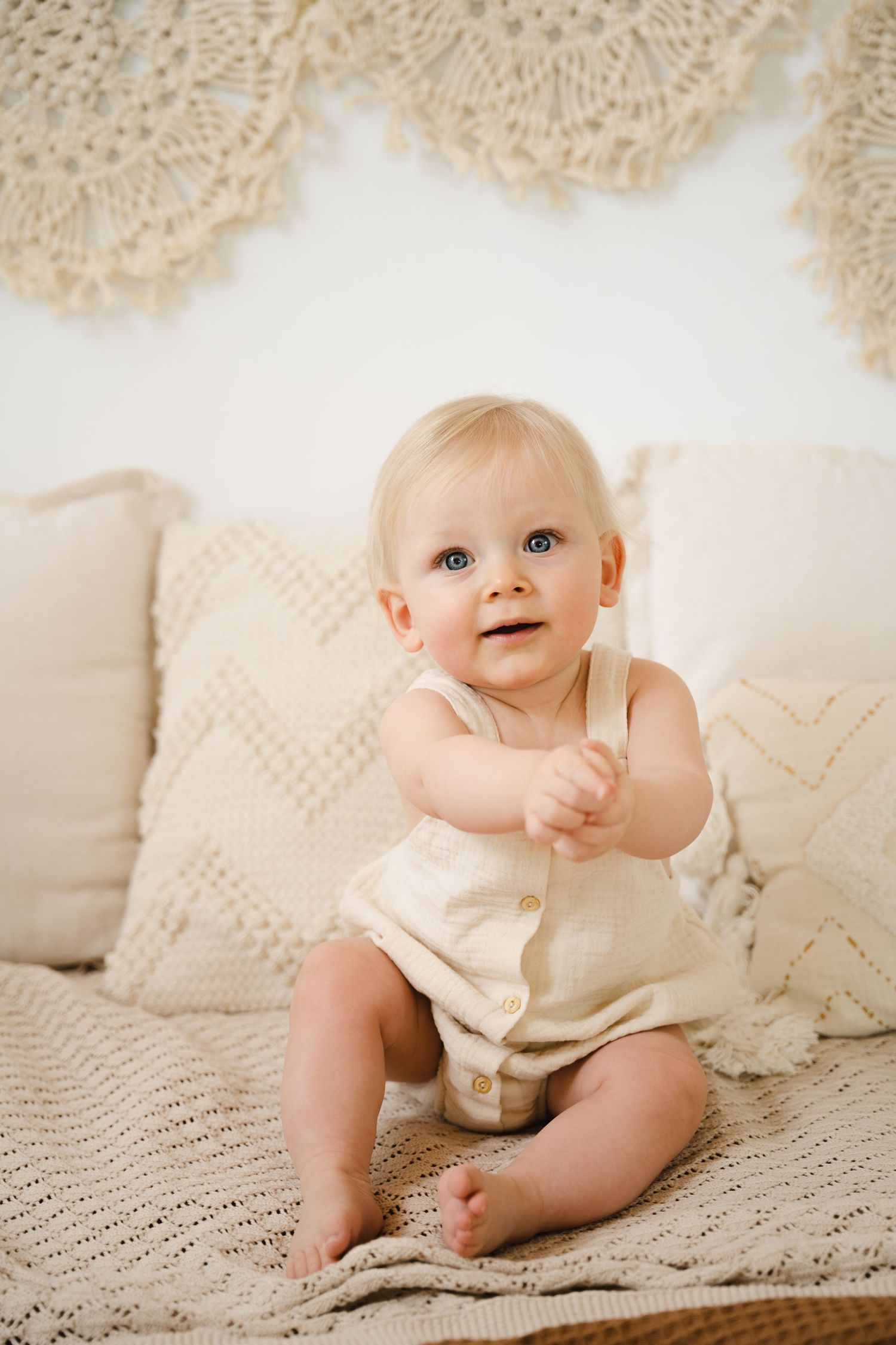 foto van vrolijke baby die net kan zitten tijdens baby photoshoot in fotostudio in zandhoven