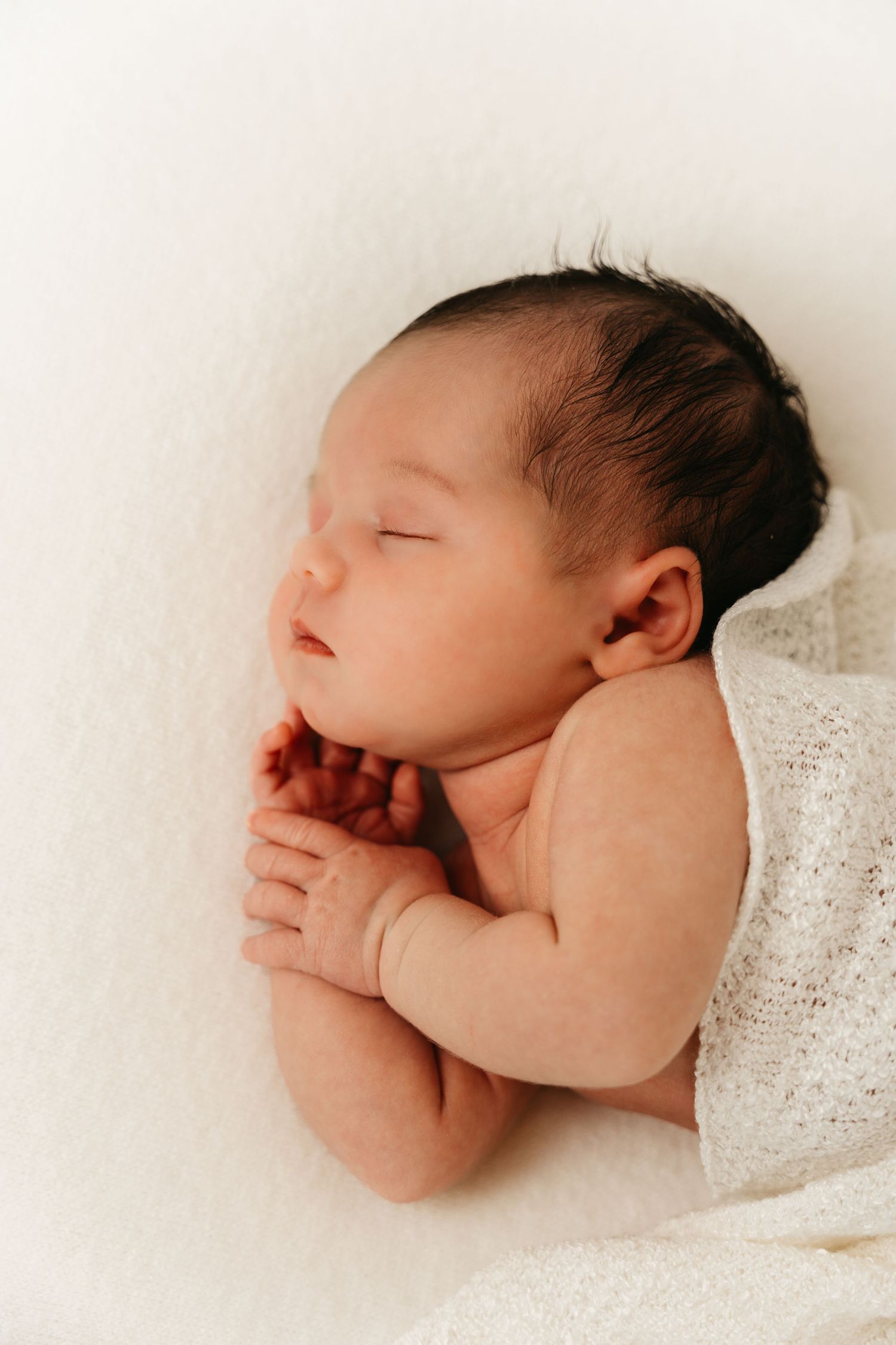 een foto van een slapende baby in een tijdloze setting tijdens een newborn reportage in studio in zandhoven