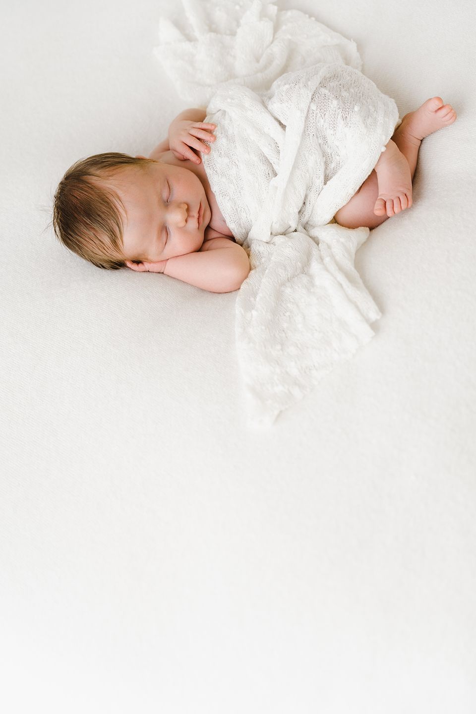foto van een newborn baby tijdens photoshoot in studio met natuurlijke kleuren