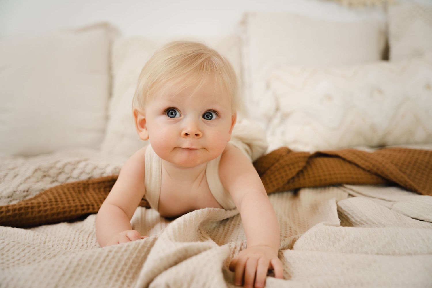 foto van vrolijke baby die net kan zitten tijdens sittersessie in fotostudio in zandhoven