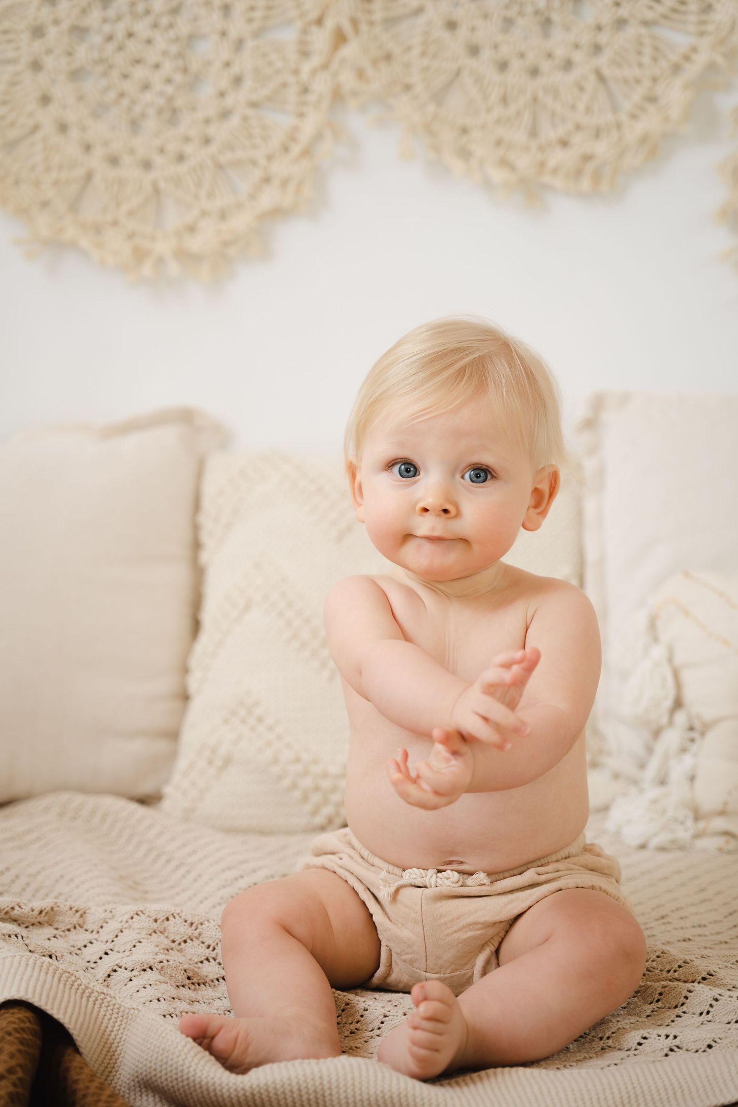 foto van vrolijke baby die net kan zitten tijdens fotoshoot in fotostudio in zandhoven