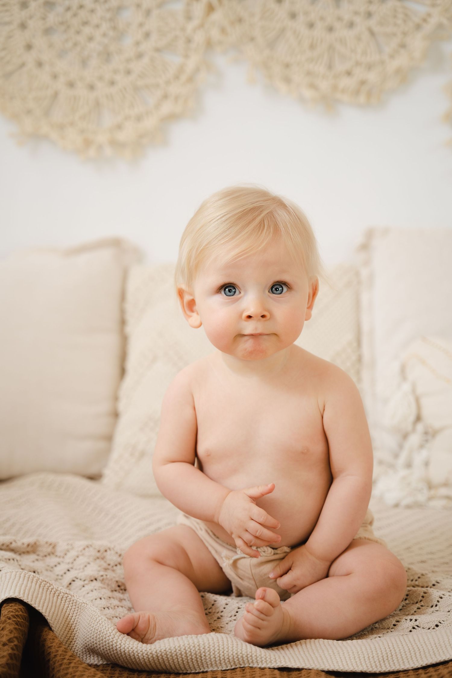 foto van vrolijke baby die net kan zitten tijdens sittersessie in fotostudio in zandhoven
