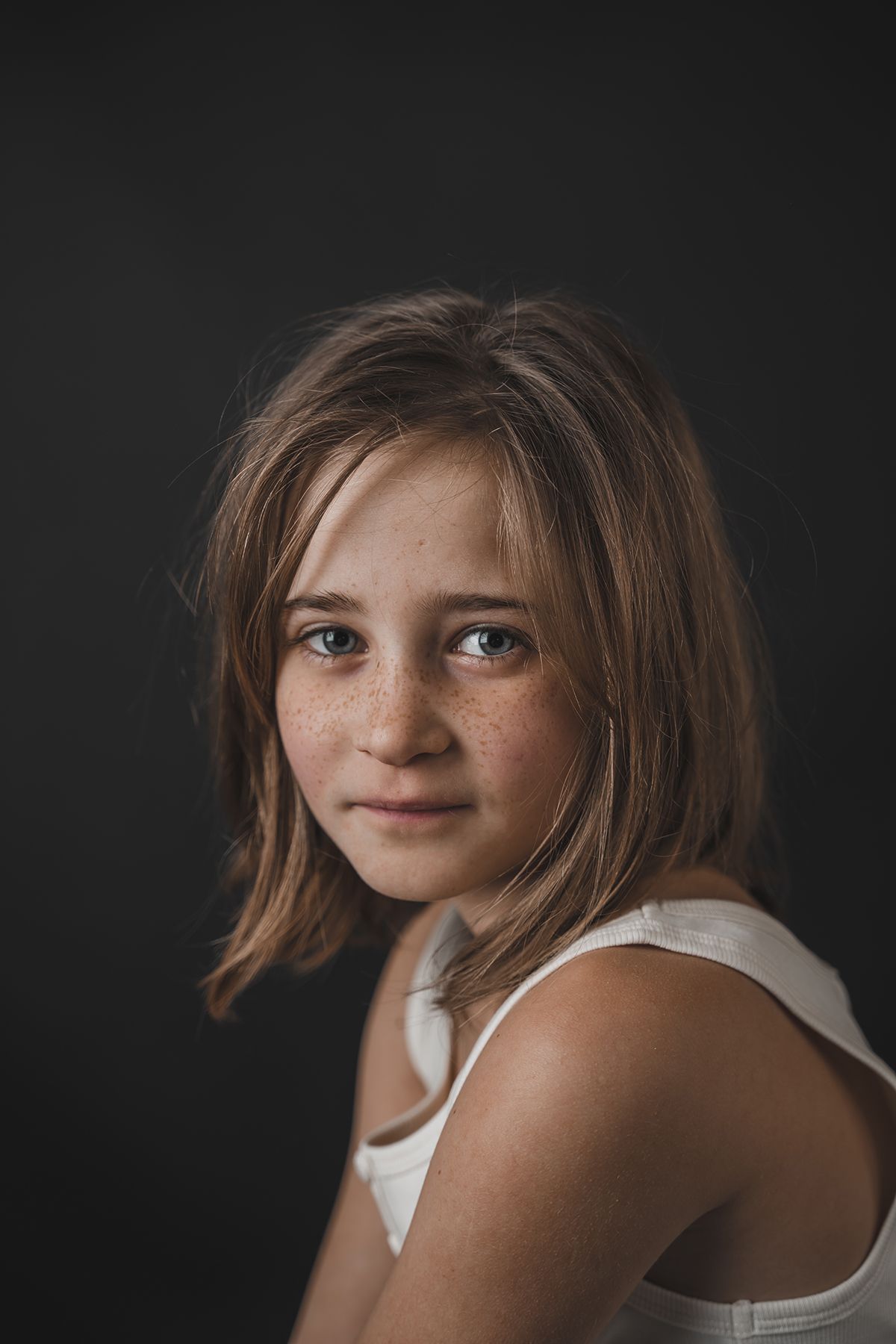 fine art portret van kind tegen zwarte achtergrond in studio in zandhoven