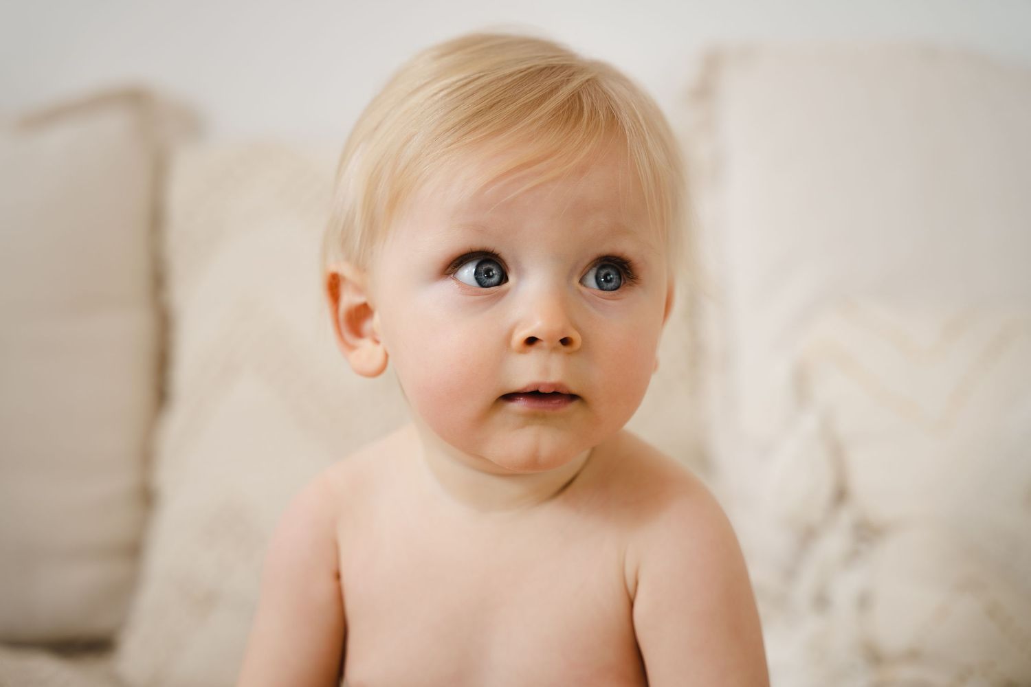 foto van vrolijke baby die net kan zitten tijdens fotoshoot in fotostudio in zandhoven