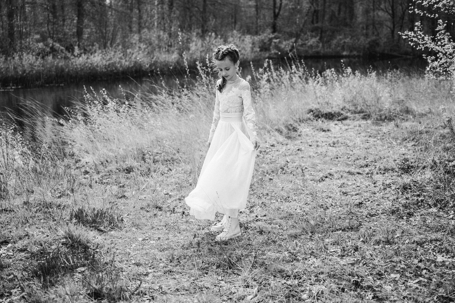 meisje in witte communiekleding tijdens communiereportage in natuur in Oelegem