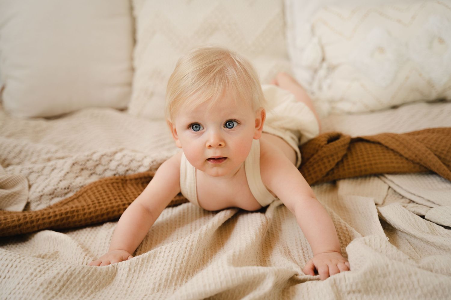 foto van vrolijke baby die net kan zitten tijdens baby photoshoot in fotostudio in zandhoven