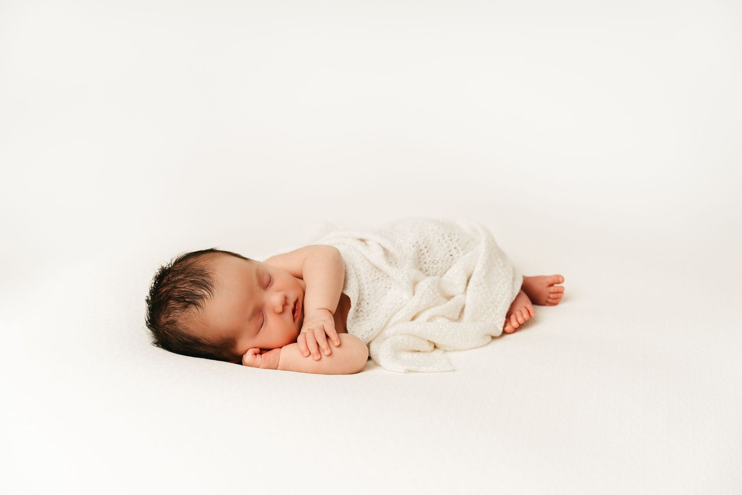 een foto van een slapende baby in een tijdloze setting tijdens een newborn reportage in studio in zandhoven