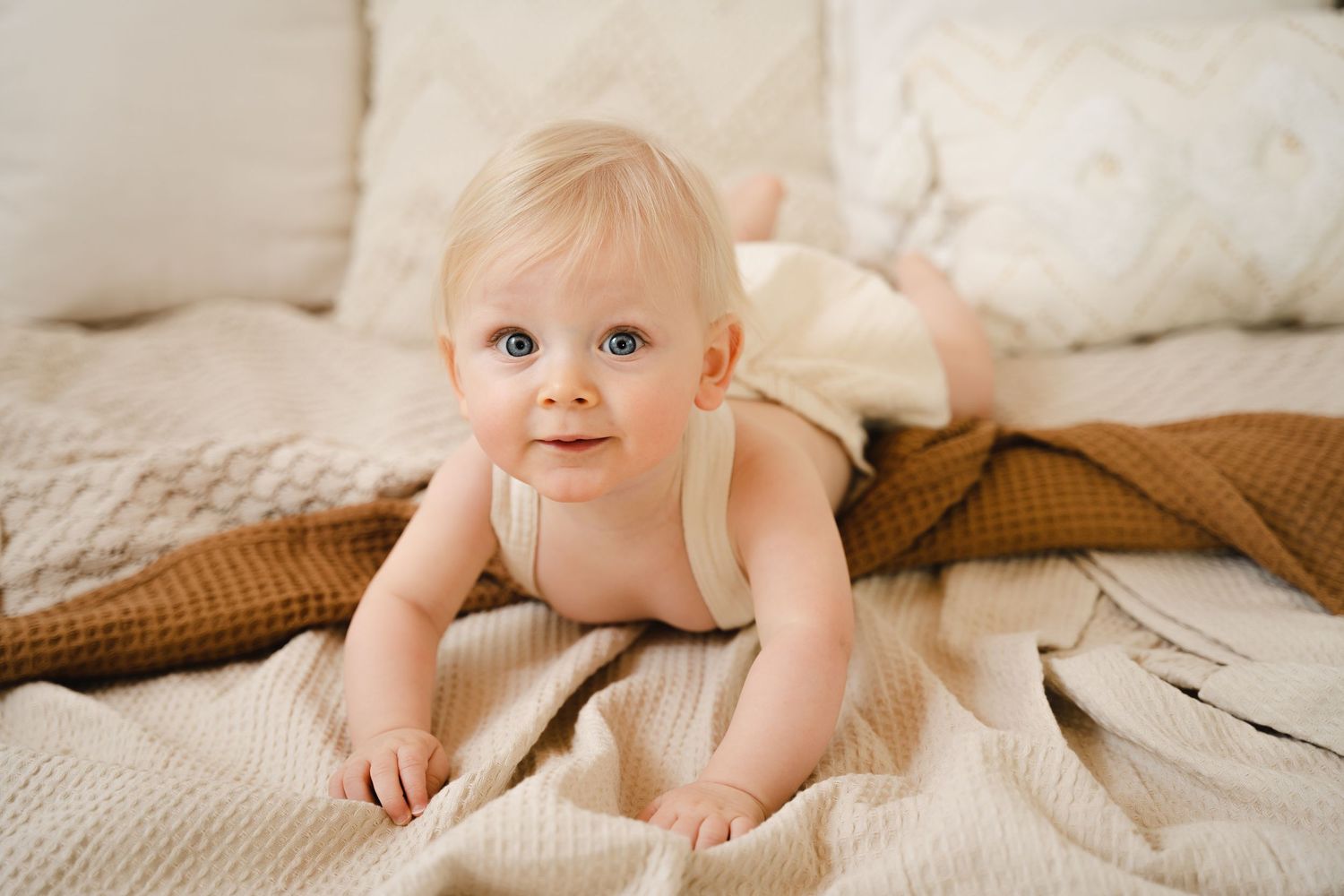 foto van vrolijke baby die net kan zitten tijdens baby photoshoot in fotostudio in zandhoven