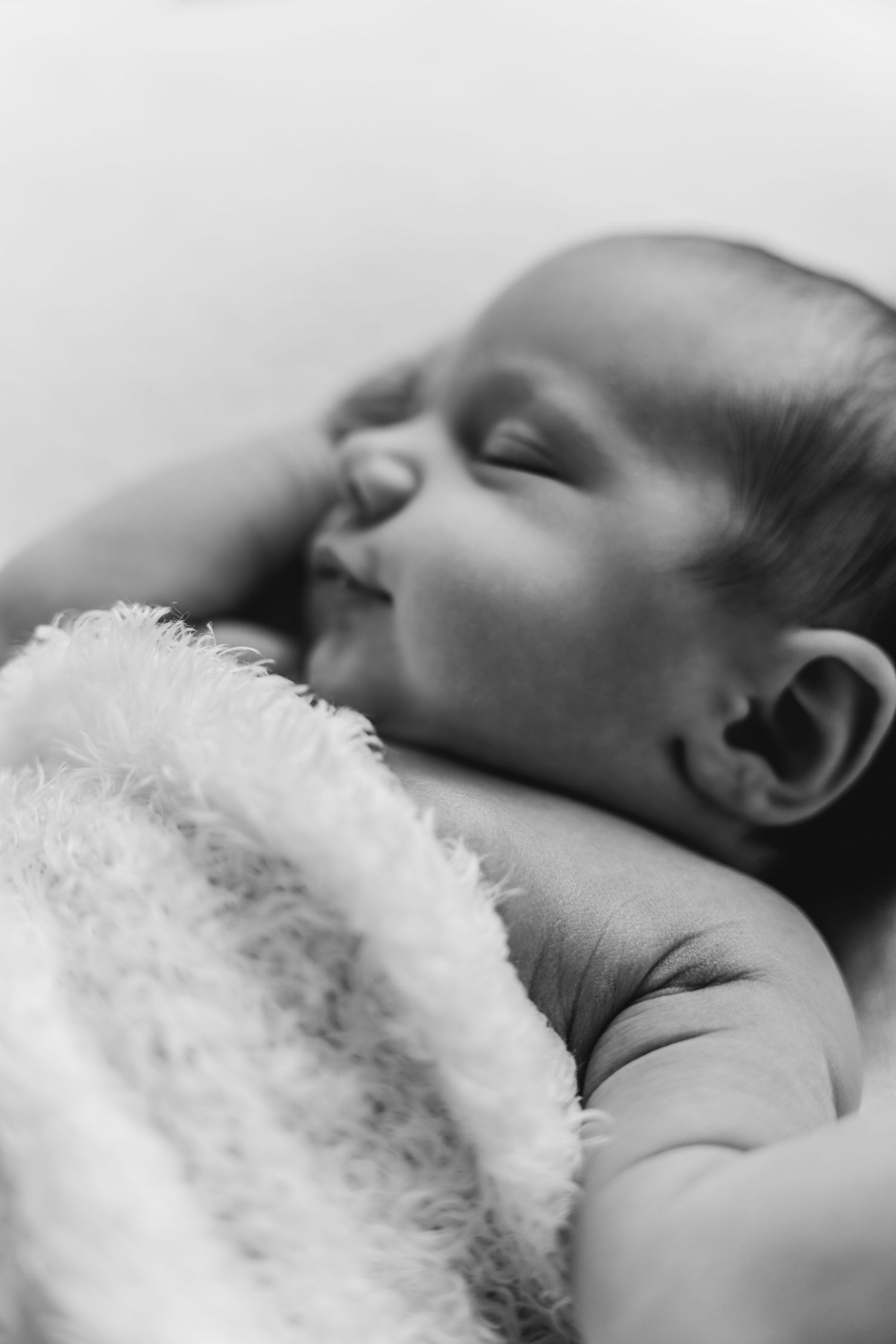 een zwartwit foto van een slapende baby in een tijdloze setting tijdens een newborn reportage in studio in zandhoven