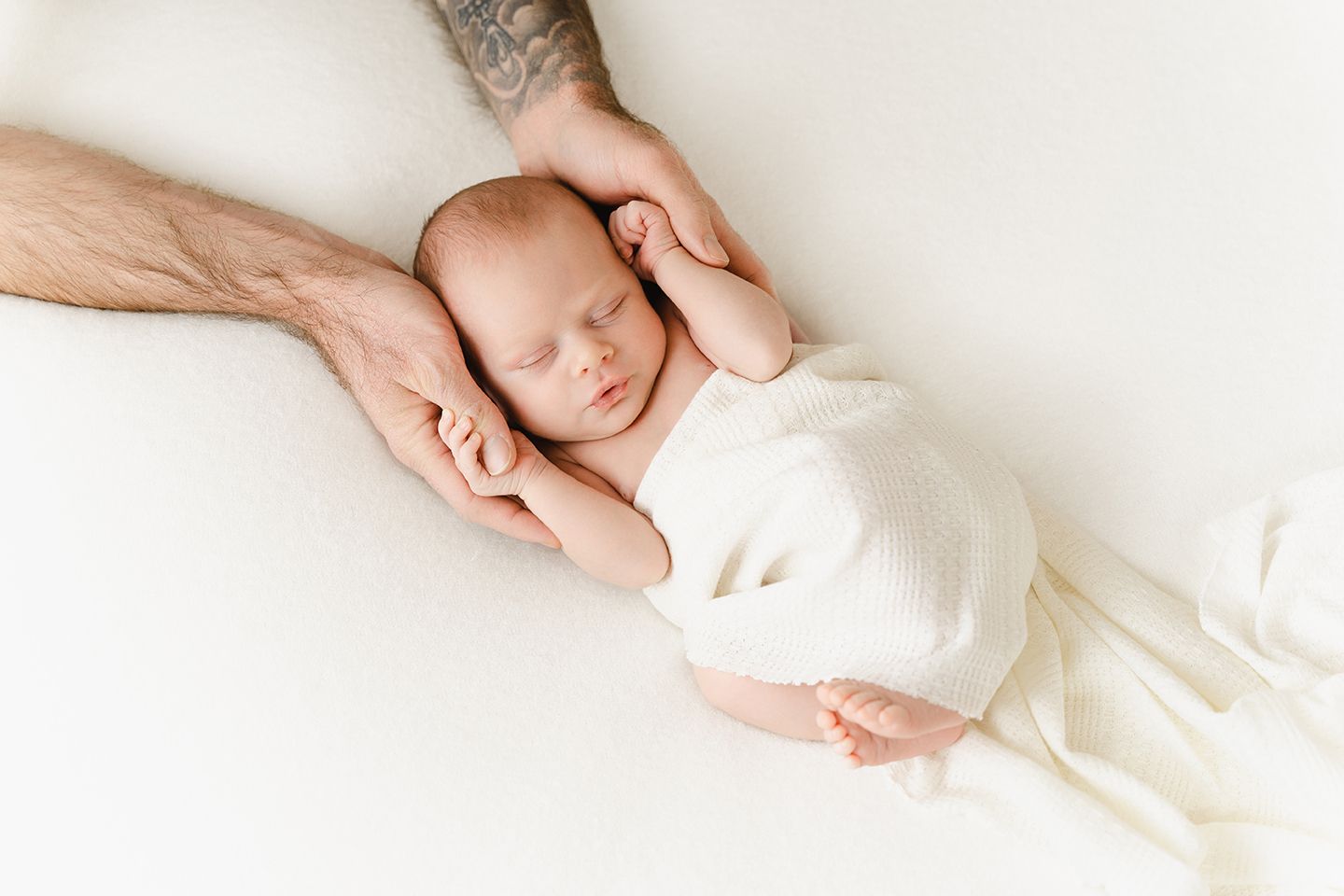 foto van een newborn baby tijdens een fotosessie in een natuurlijk witte fotostudio in zandhoven