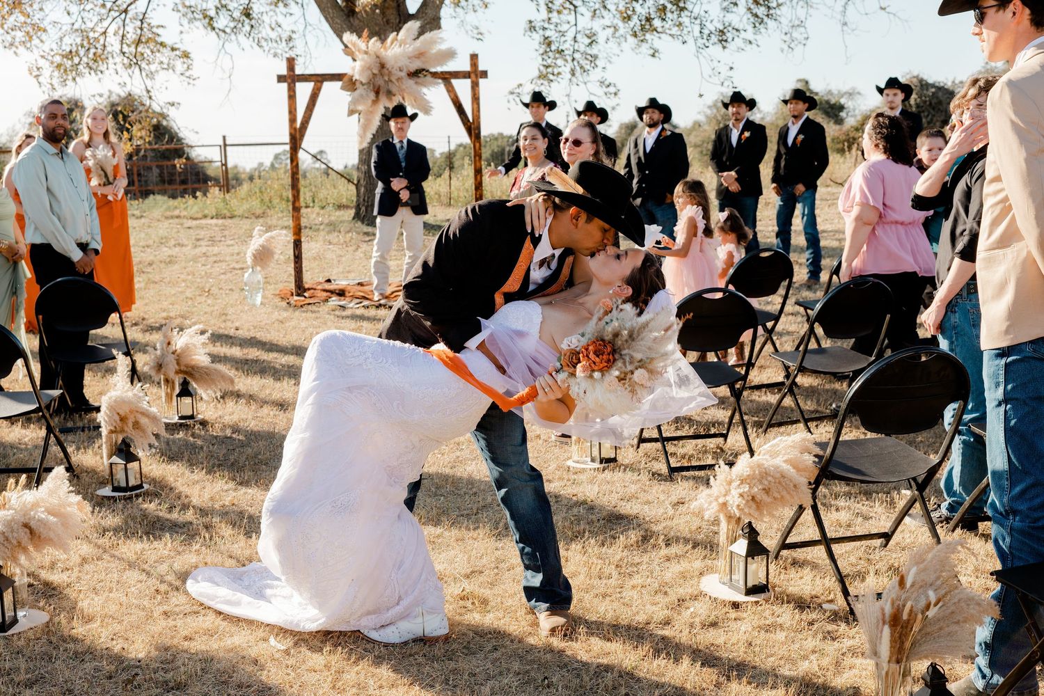 Outdoor rustic wedding ceremony with a wooden arch and seated guests
