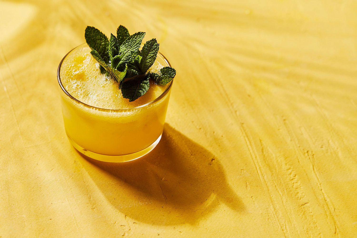 Lemon G&T cocktail on yellow background