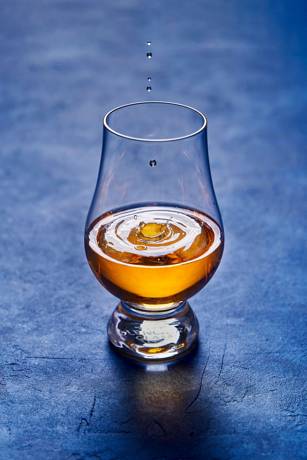 Whisky ripple drop on blue background