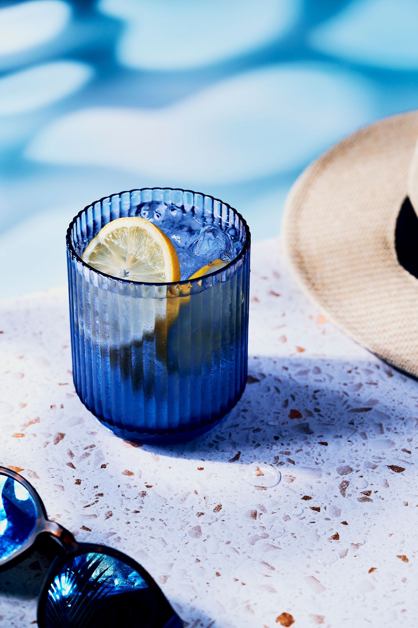 Sparkling water in blue grass on poolside summer vibes