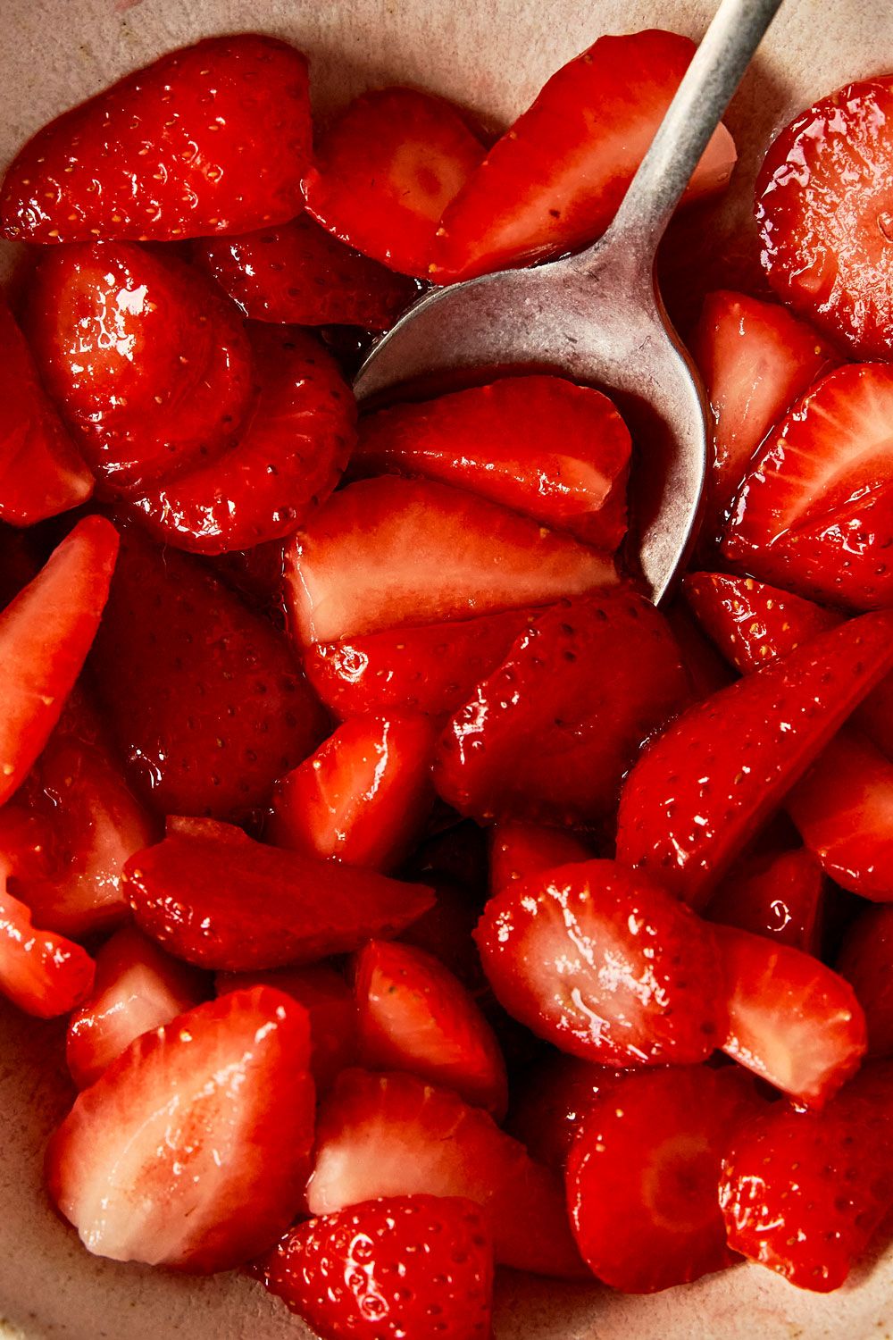 Macro shot of macerated strawberries with a spoon