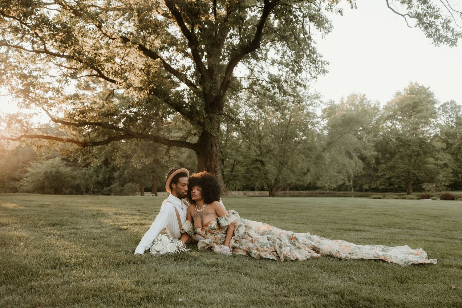 A couple shares an intimate moment together in a sunlit meadow during golden hour.