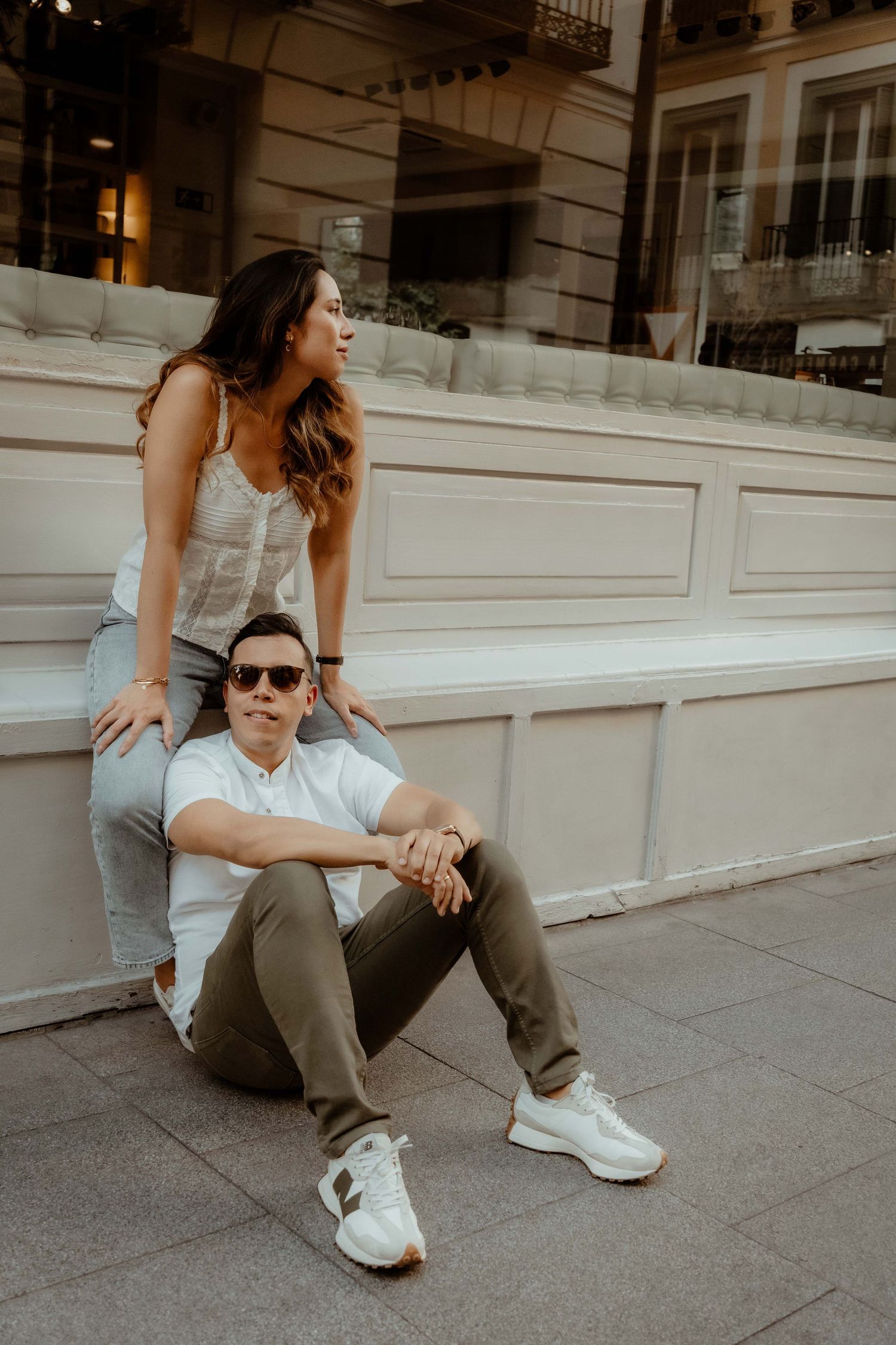 Pareja sentada en calle durante sesión preboda – fotografía de bodas Madrid