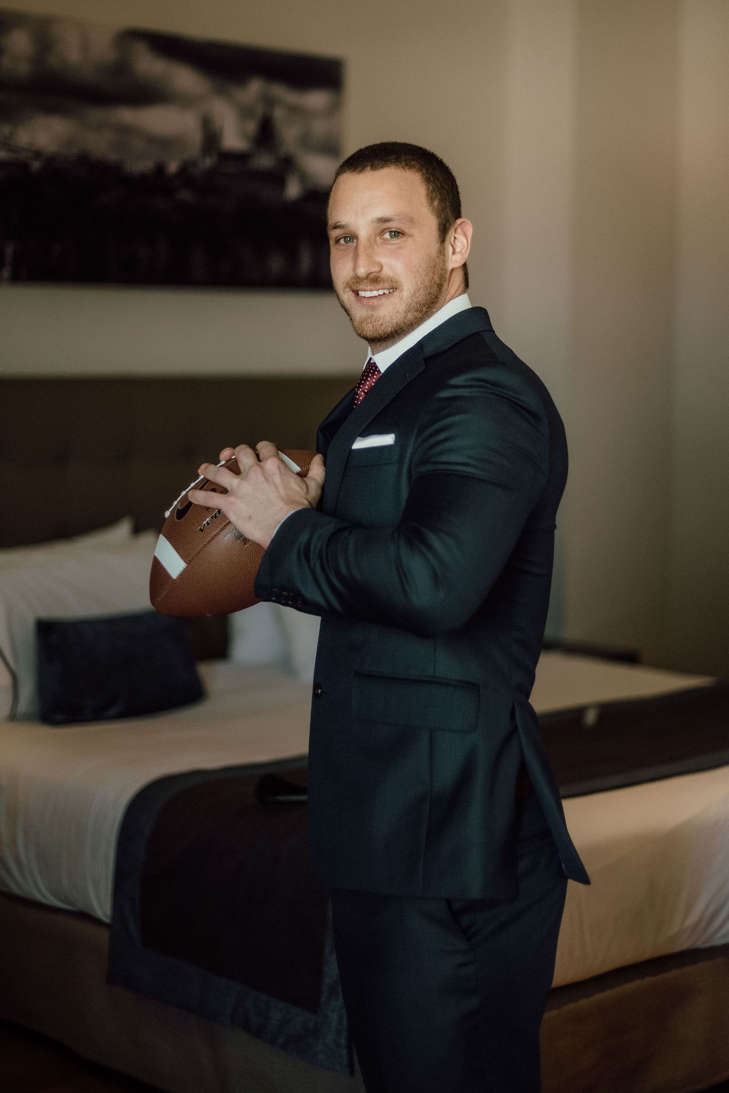 Retrato de novio durante preparativos con una pelota de fútbol americano – fotógrafo de bodas Madrid