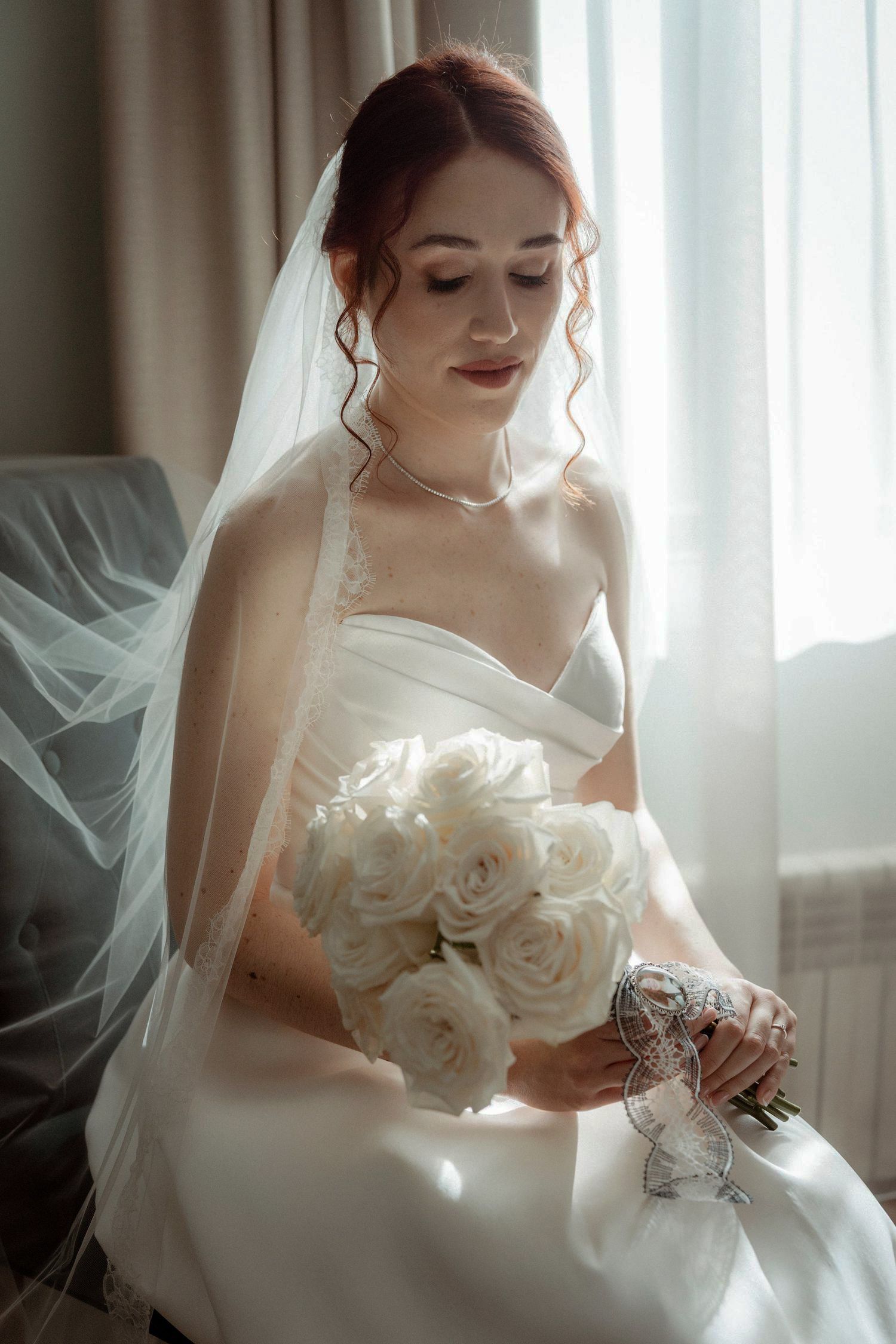 Retrato de novia con ramo junto a ventana – fotógrafo de bodas Madrid