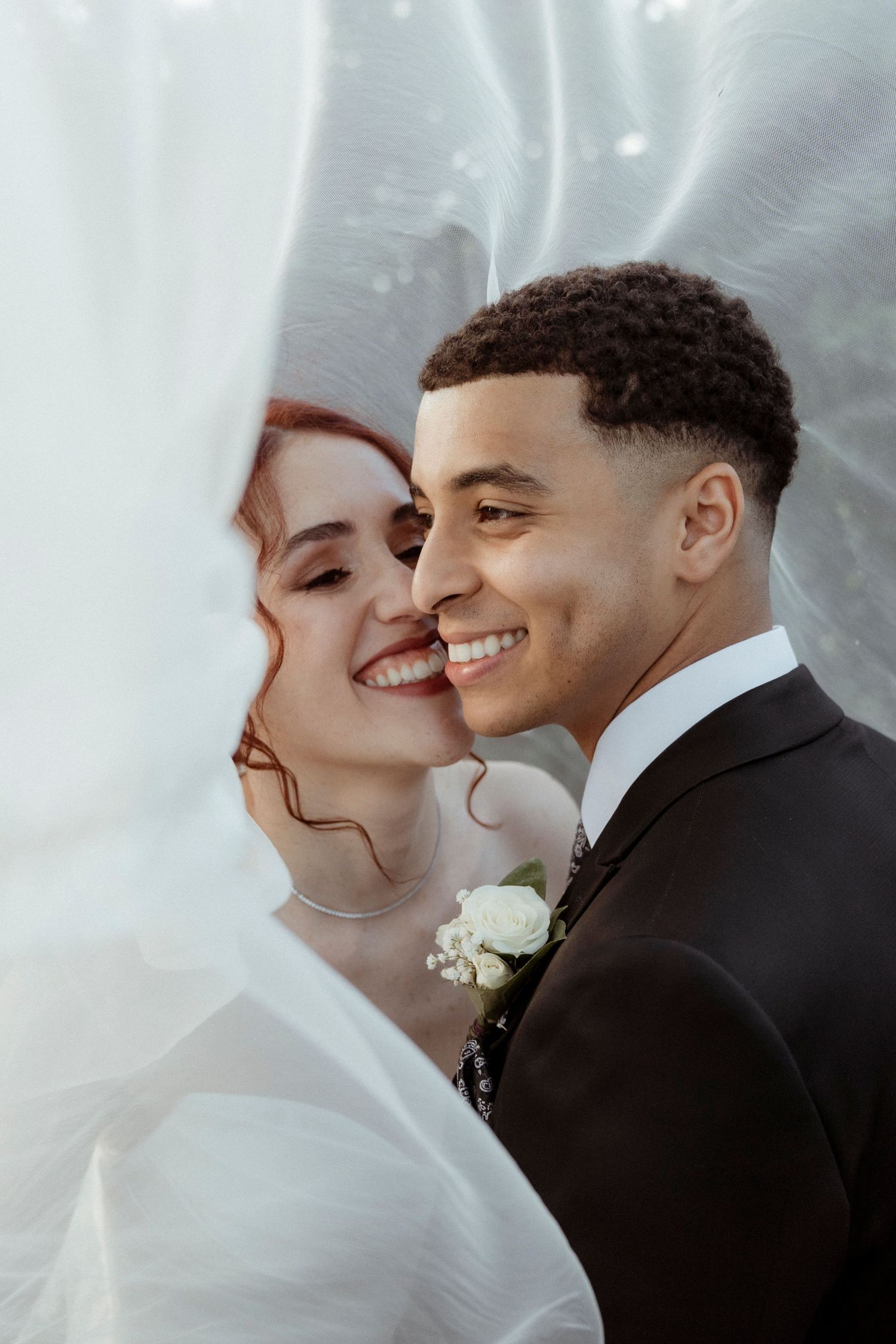 Pareja de novios besándose bajo el velo – fotografía de bodas Madrid estilo editorial