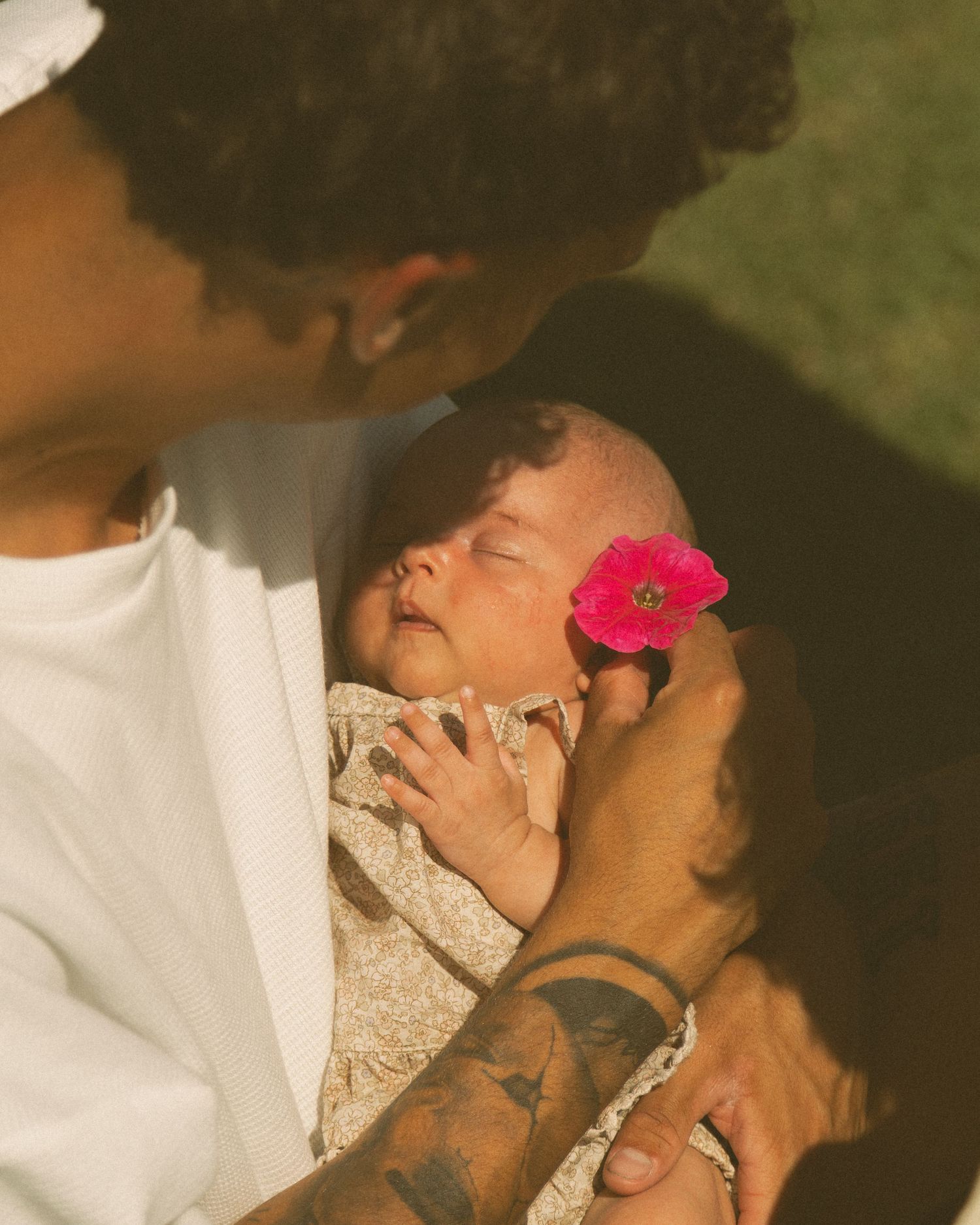 moment captured with pink flower accent in moody lighting.