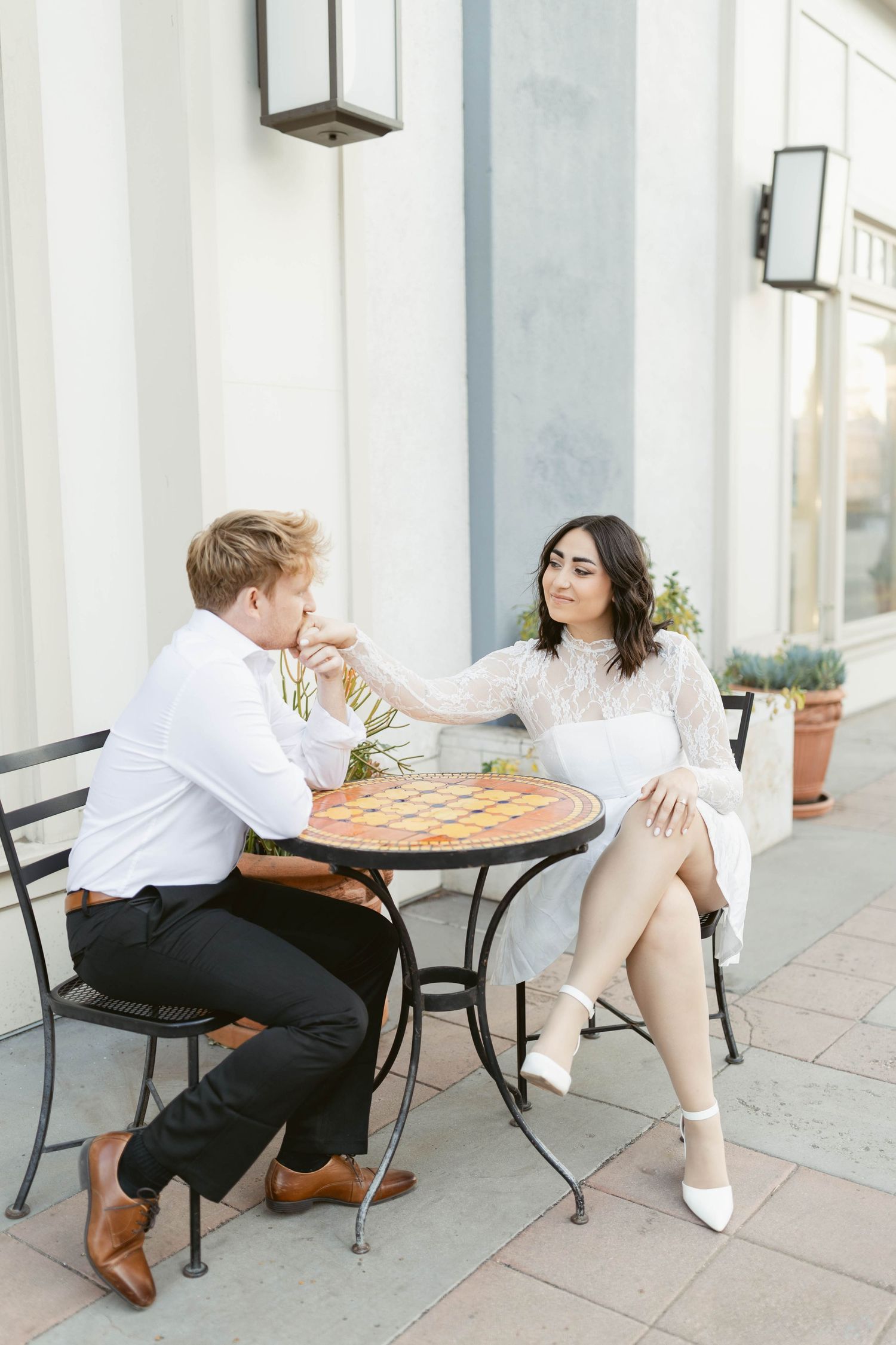 Couple enjoying pizza at an outdoor cafe table.