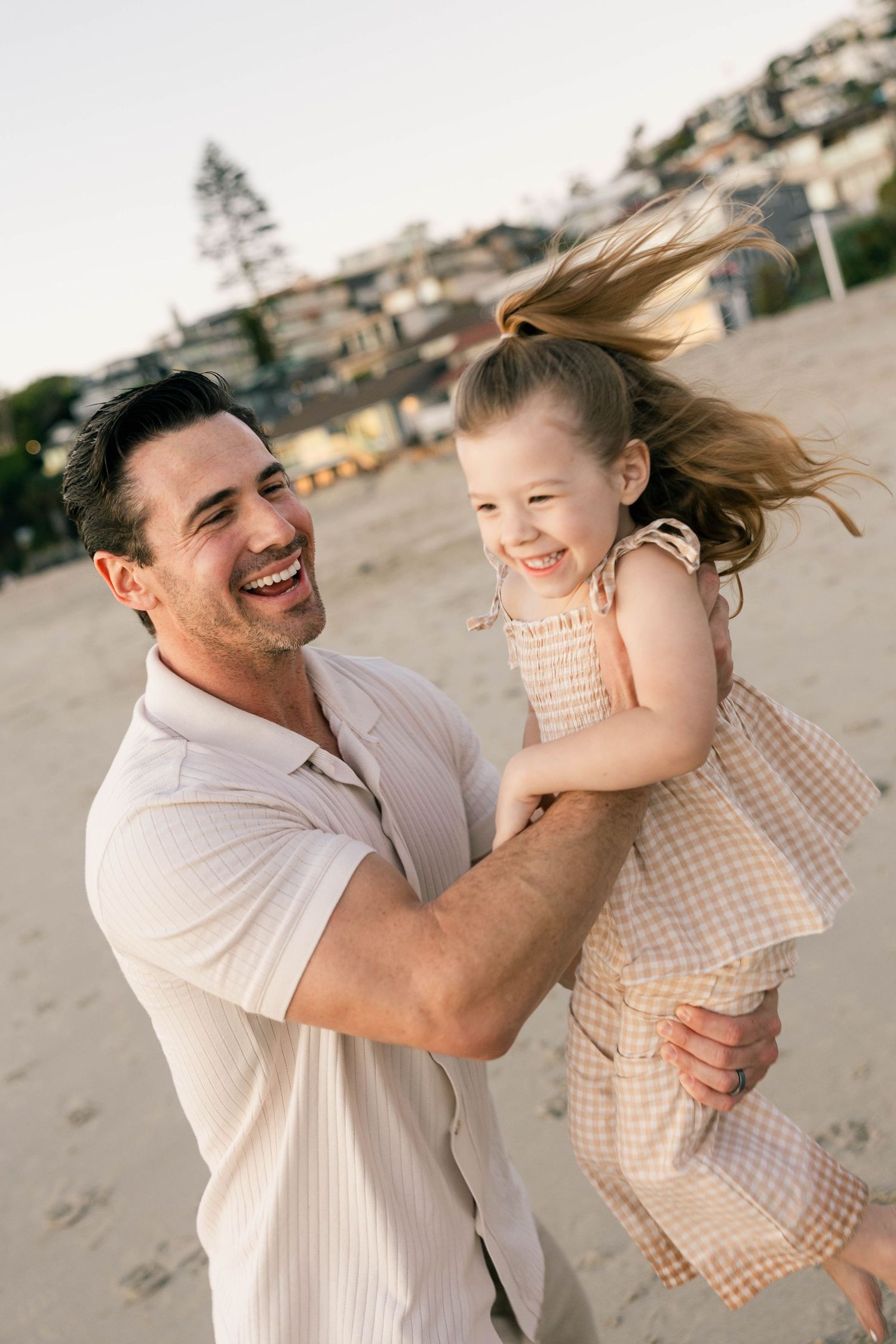 Joyful moment captured between parent and child playing on the beach.