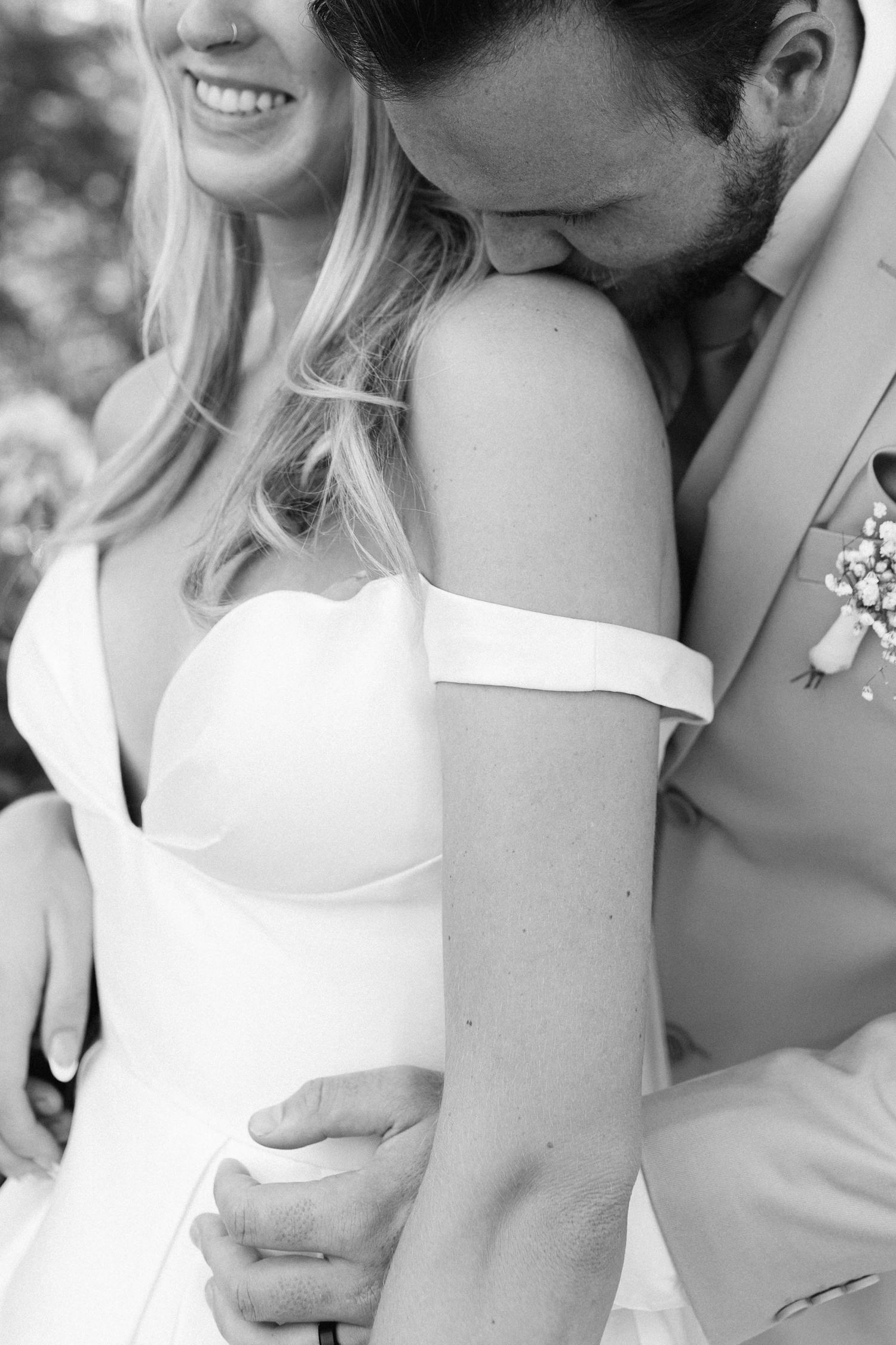 A tender black and white close-up captures an intimate wedding moment.