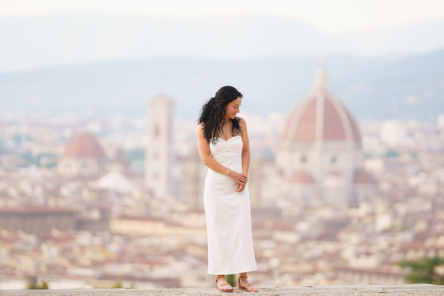 A panoramic view of Florence, Italy with the iconic Duomo cathedral dome rising above the historic cityscape.
