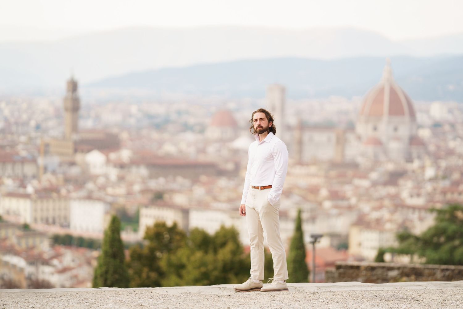 A panoramic view of Florence, Italy with the iconic Duomo cathedral dome rising above the historic cityscape.